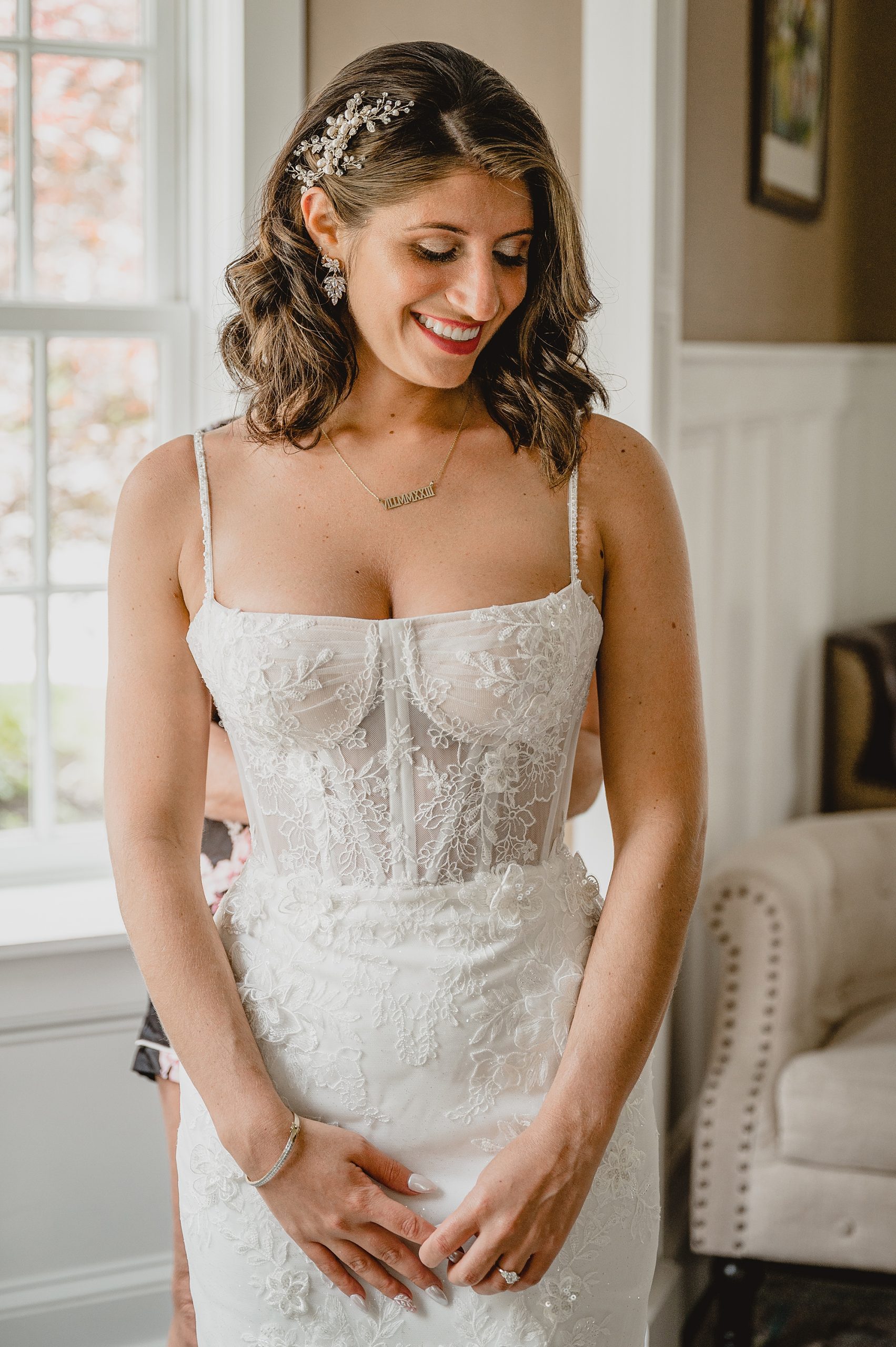 bride smiles looking down in wedding gown with corset bodice 