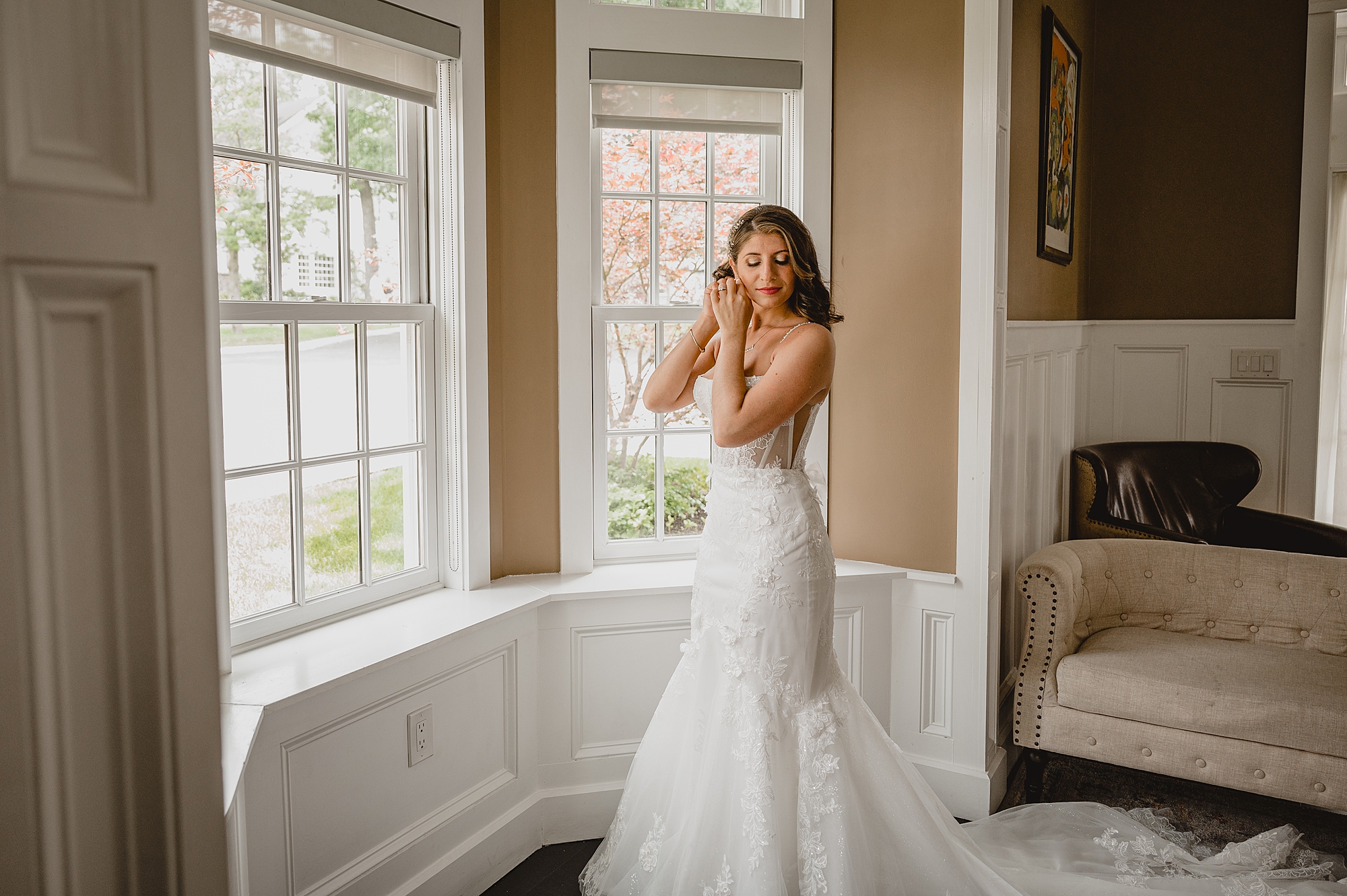 bride puts on earrings during prep for wedding day at the Ryland Inn