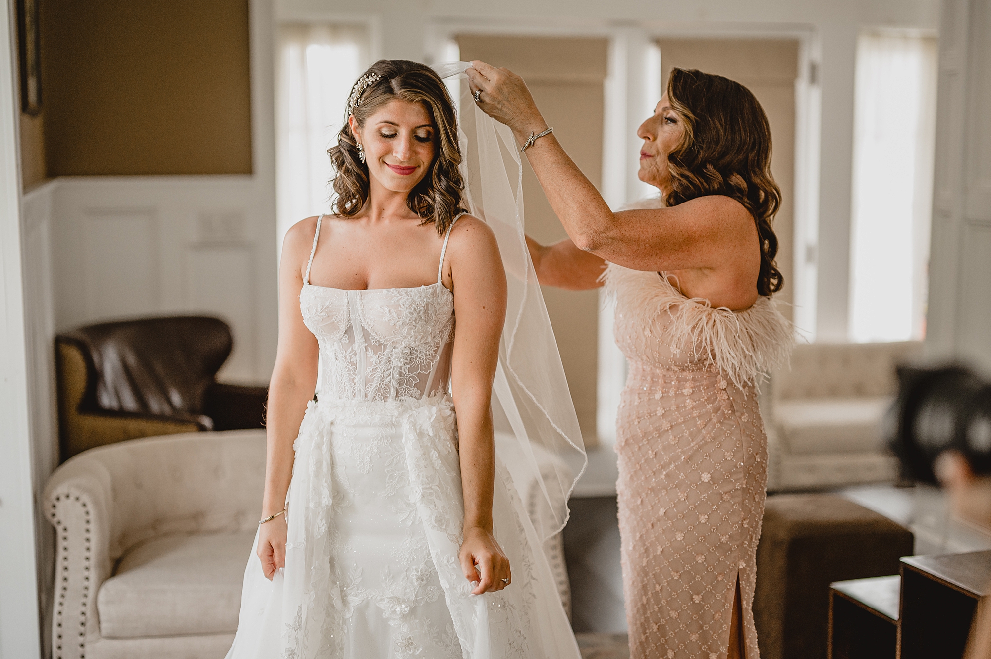 bridesmaid helps bride with veil placement