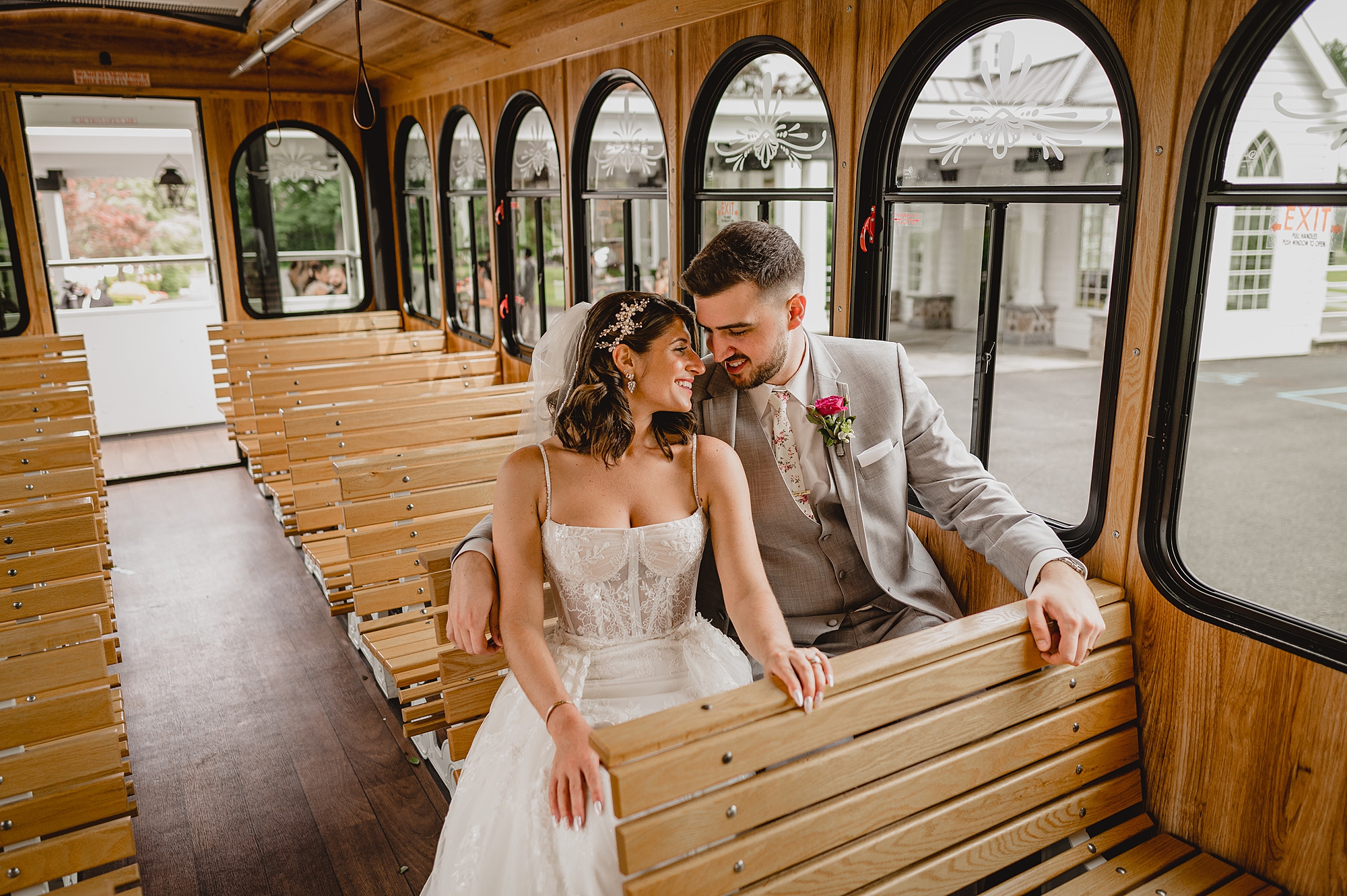 newlyweds snuggle on wooden seat of trolley car