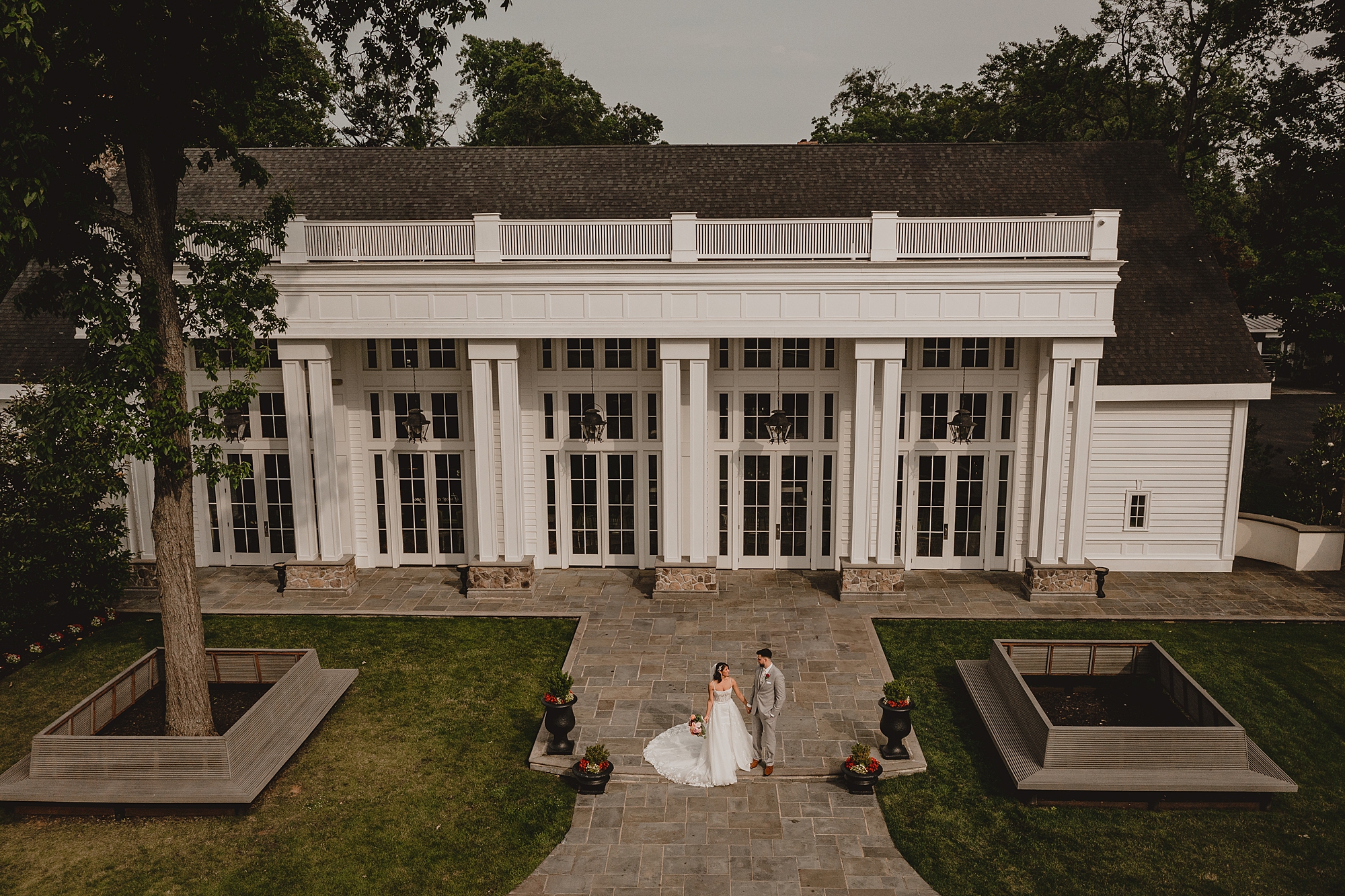 bride and groom kiss holding hands outside the Ryland Inn
