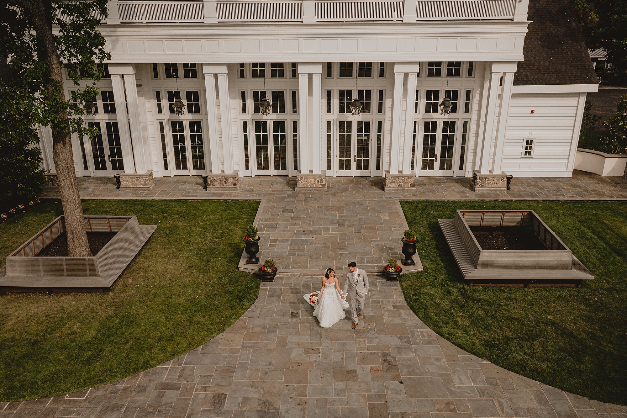 bride and groom walk in front of the Ryland Inn
