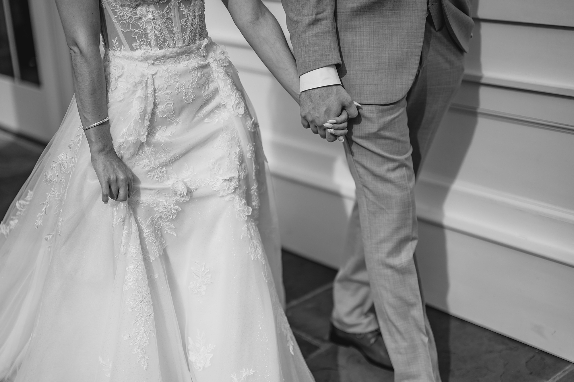 close up of bride and groom holding hands