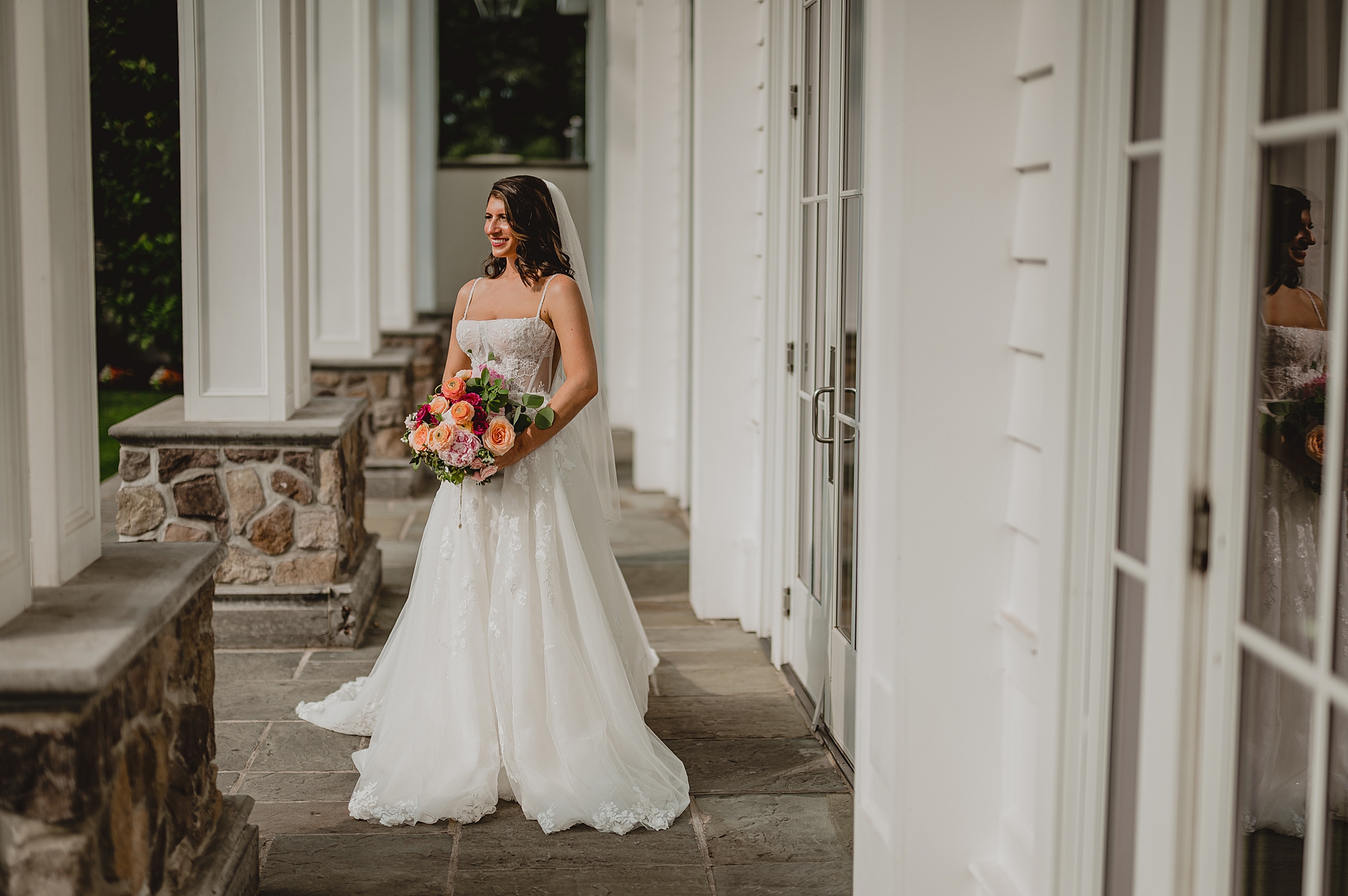 bride stands in front of the Ryland Inn holding bouquet