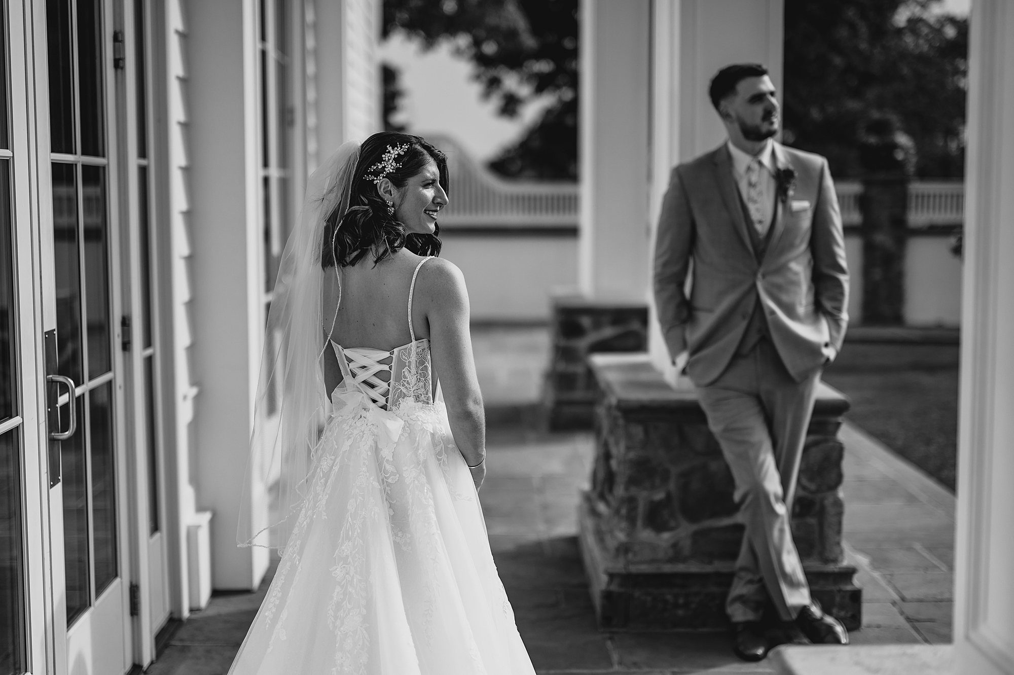 bride and groom stand part between pillars at the Ryland Inn