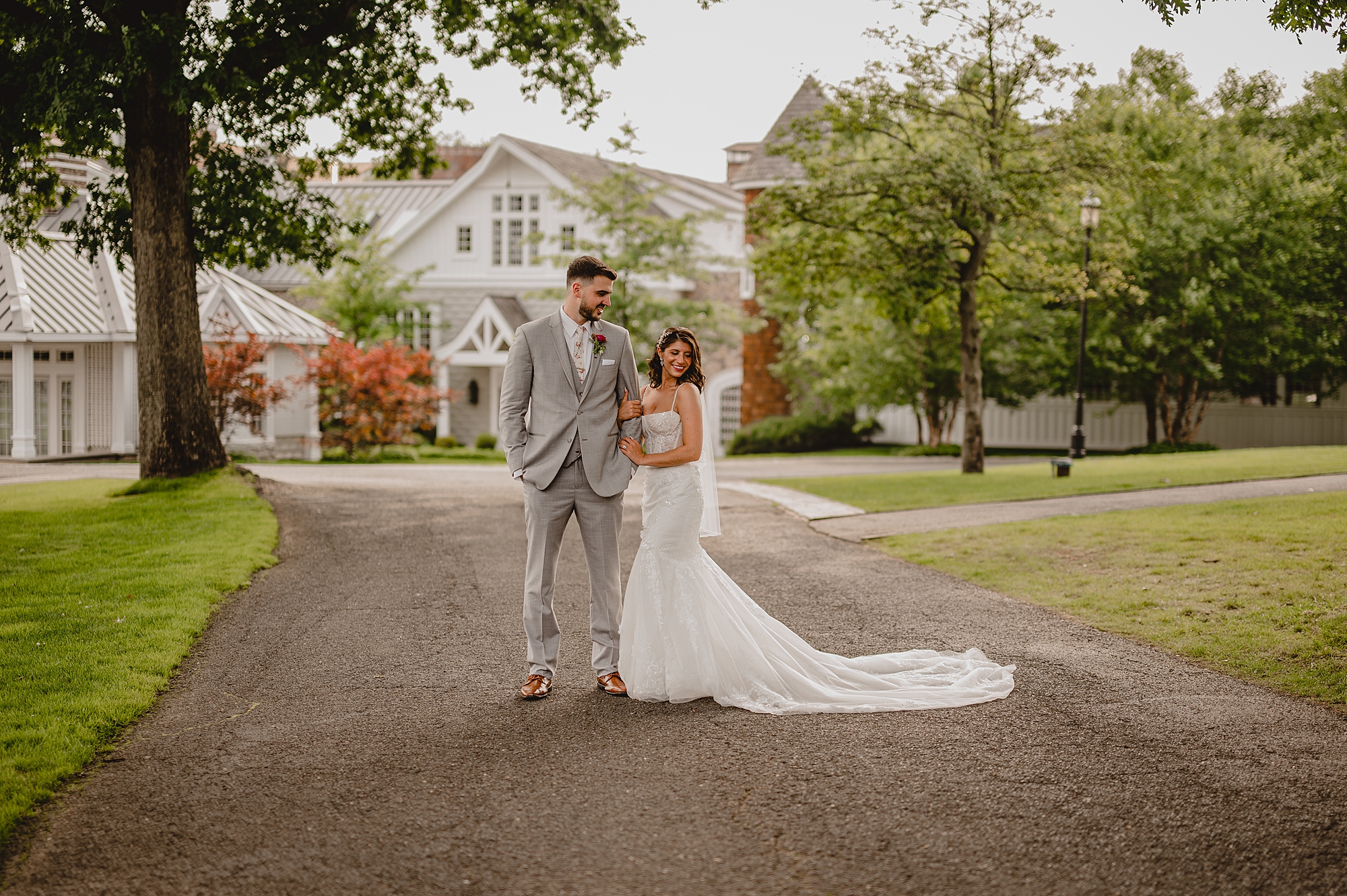 bride and groom stand together on the driveway of the Ryland Inn