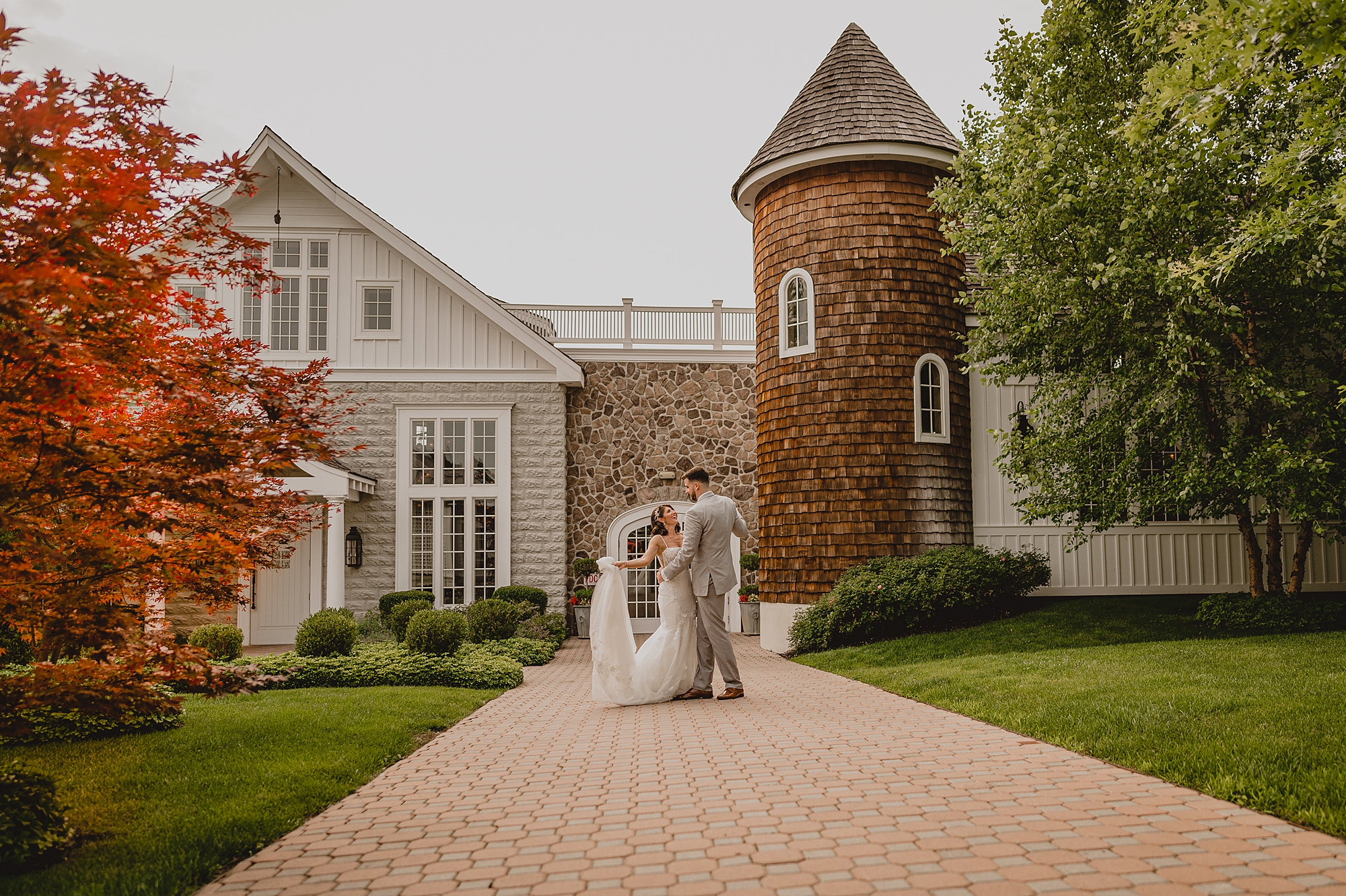 groom twirls bride outside building of the Ryland Inn