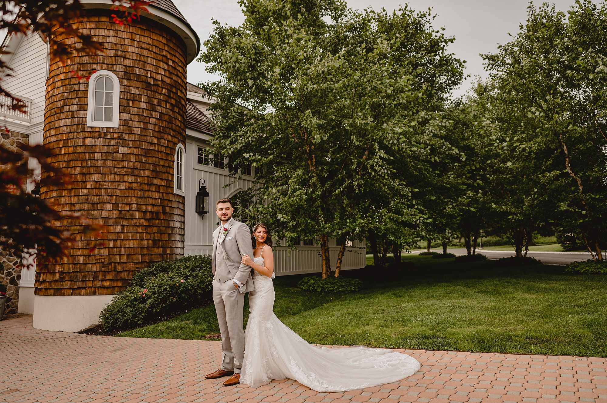 bride hugs groom from behind leaning against his back