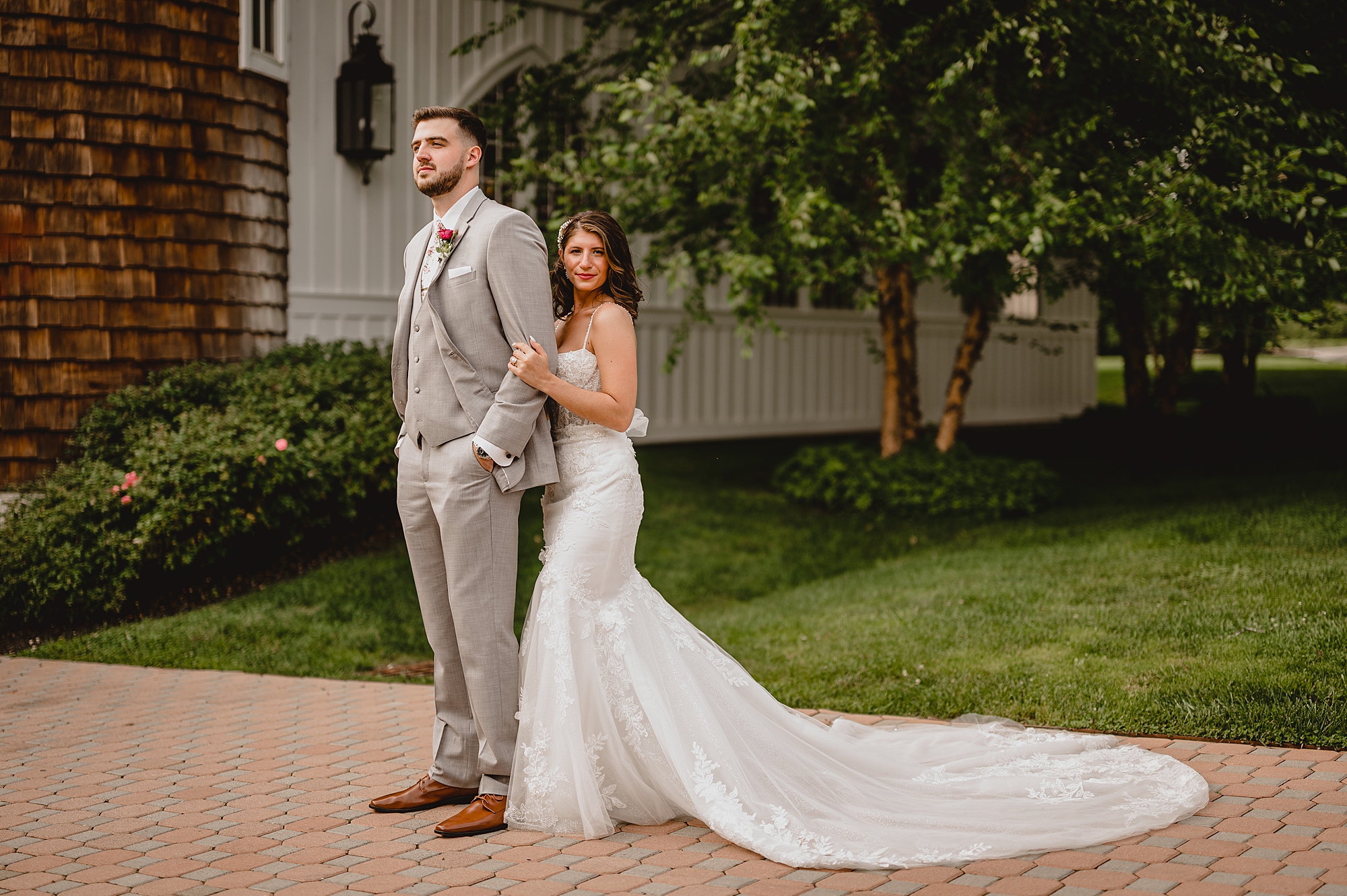 bride hugs groom from behind on driveway at the Ryland Inn