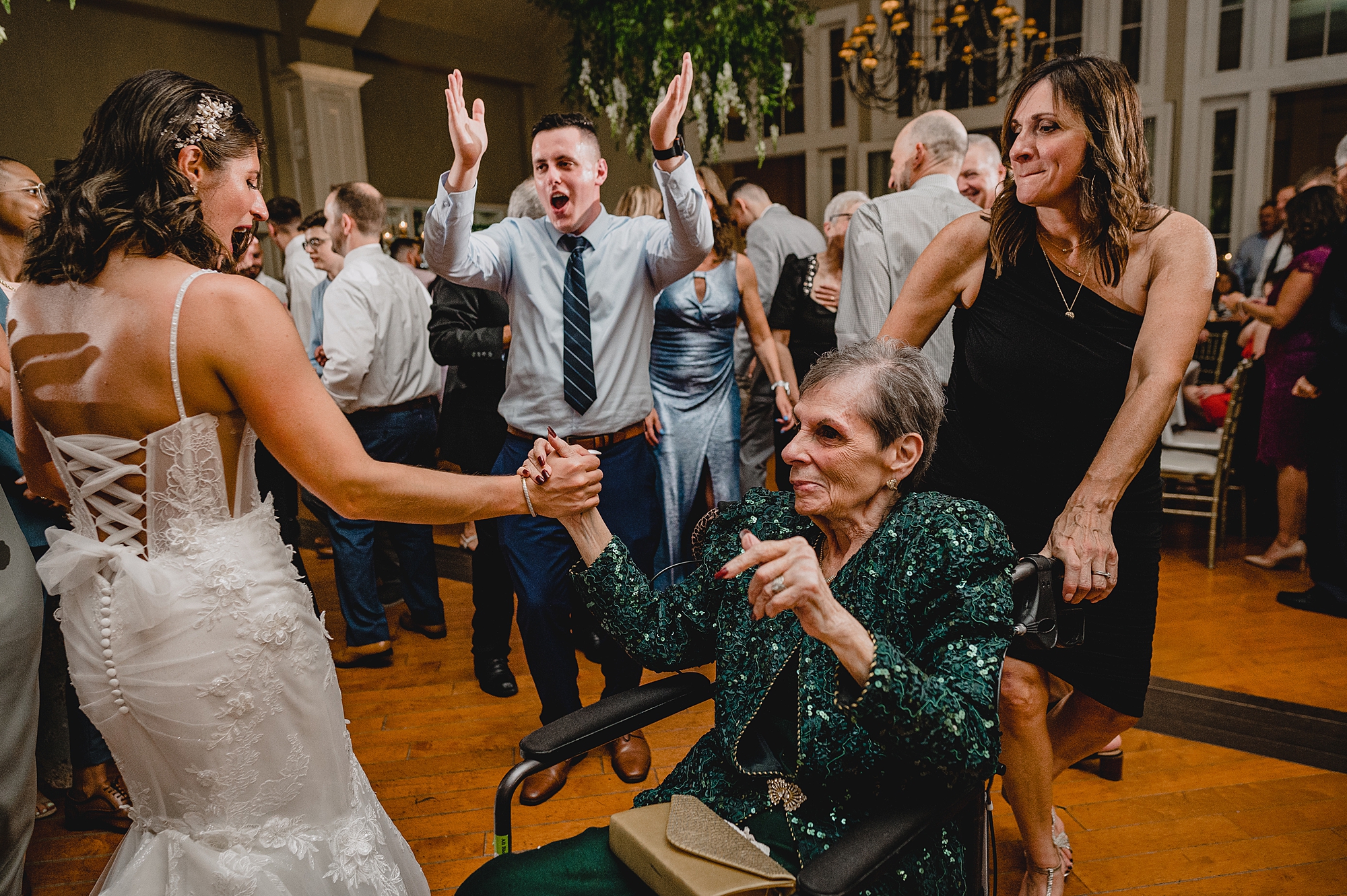 bride dances with woman in wheelchair during wedding reception