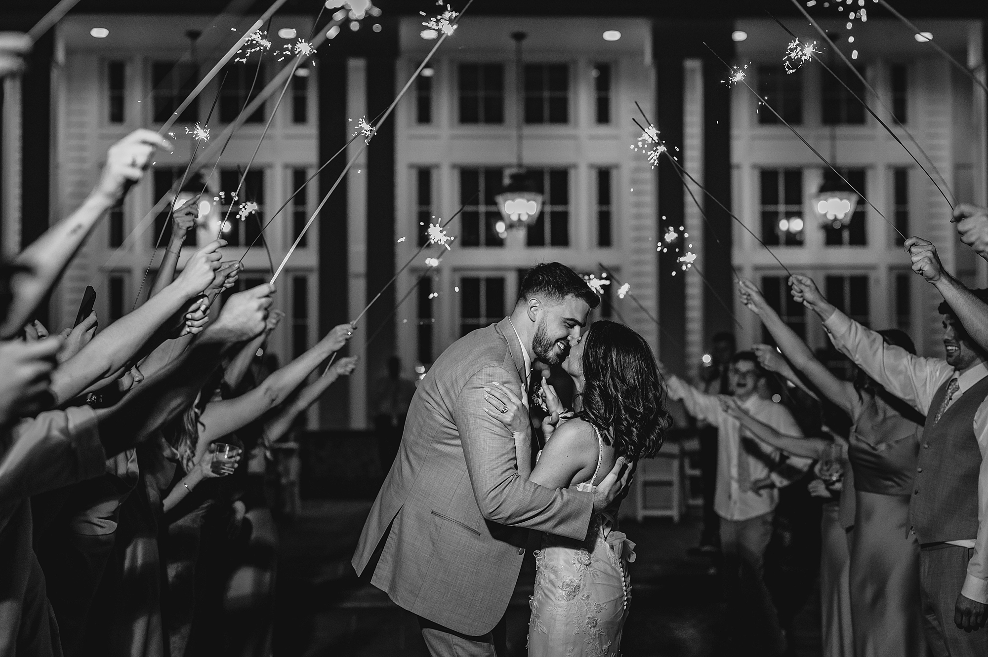 newlyweds kiss during sparkler exit from reception