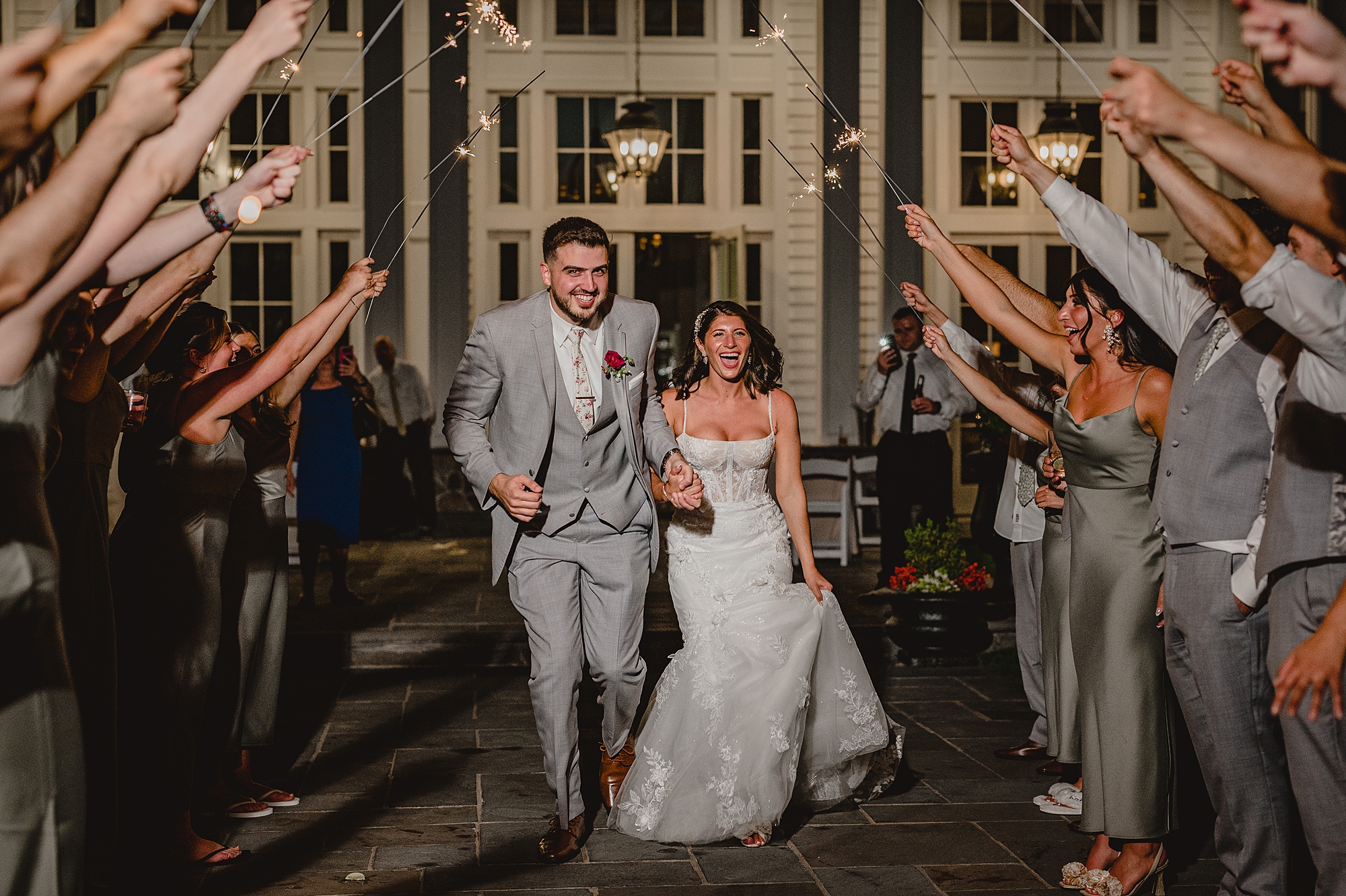 newlyweds hold hands leaving through sparklers at the Ryland Inn