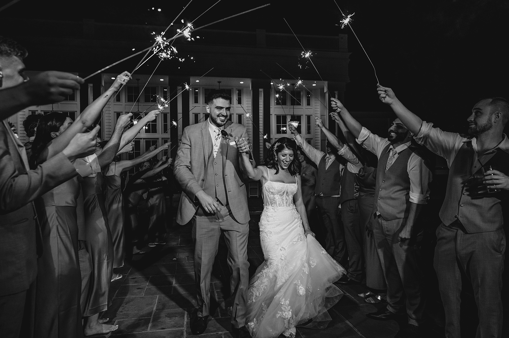 newlyweds hold hands running through sparkler exit at the Ryland Inn