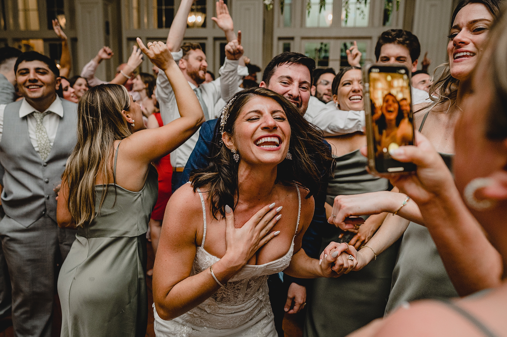 bride laughs with wedding guests around her at the Ryland Inn