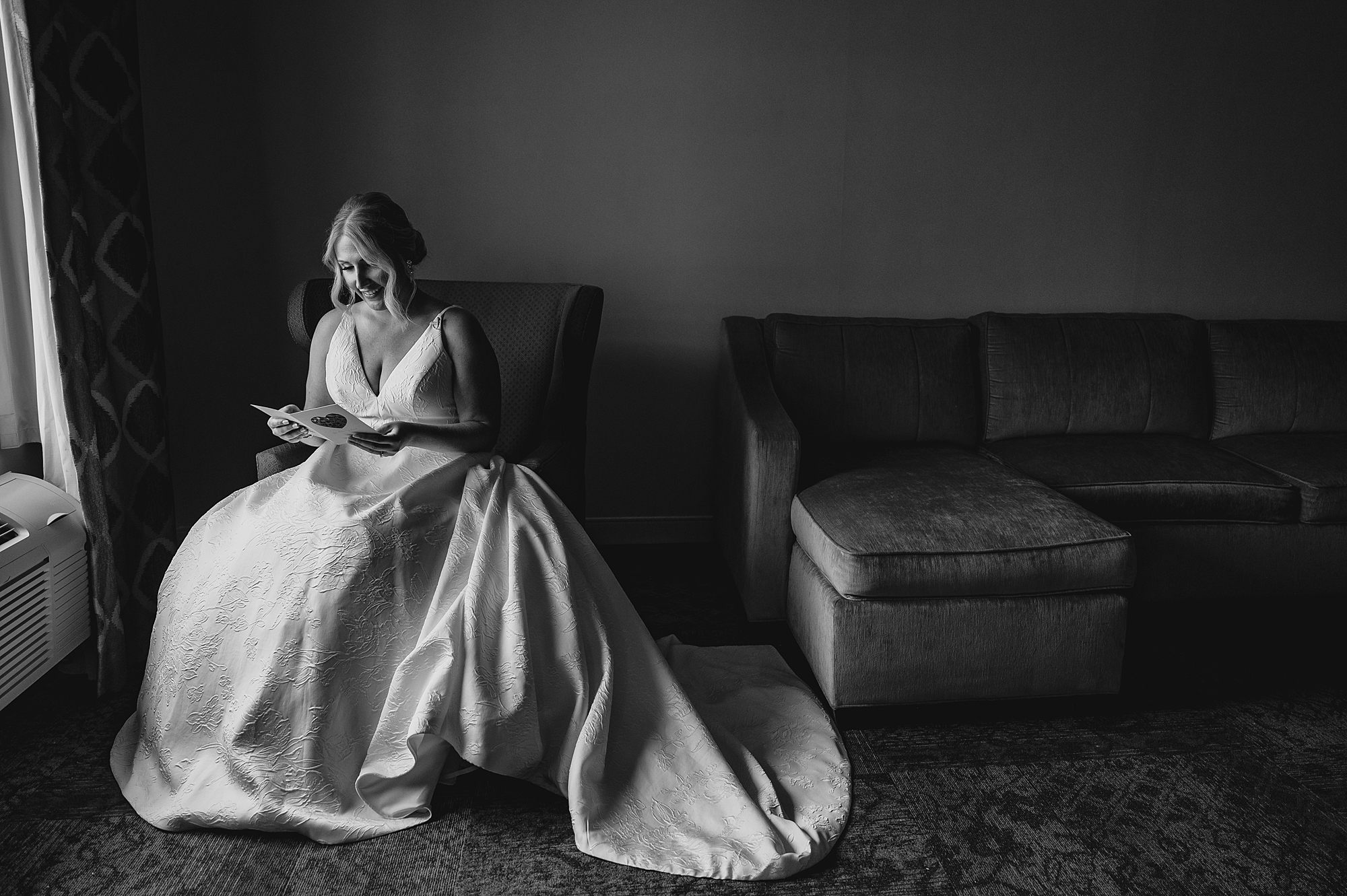 bride sits in hotel room reading letter from fiancee on morning of wedding