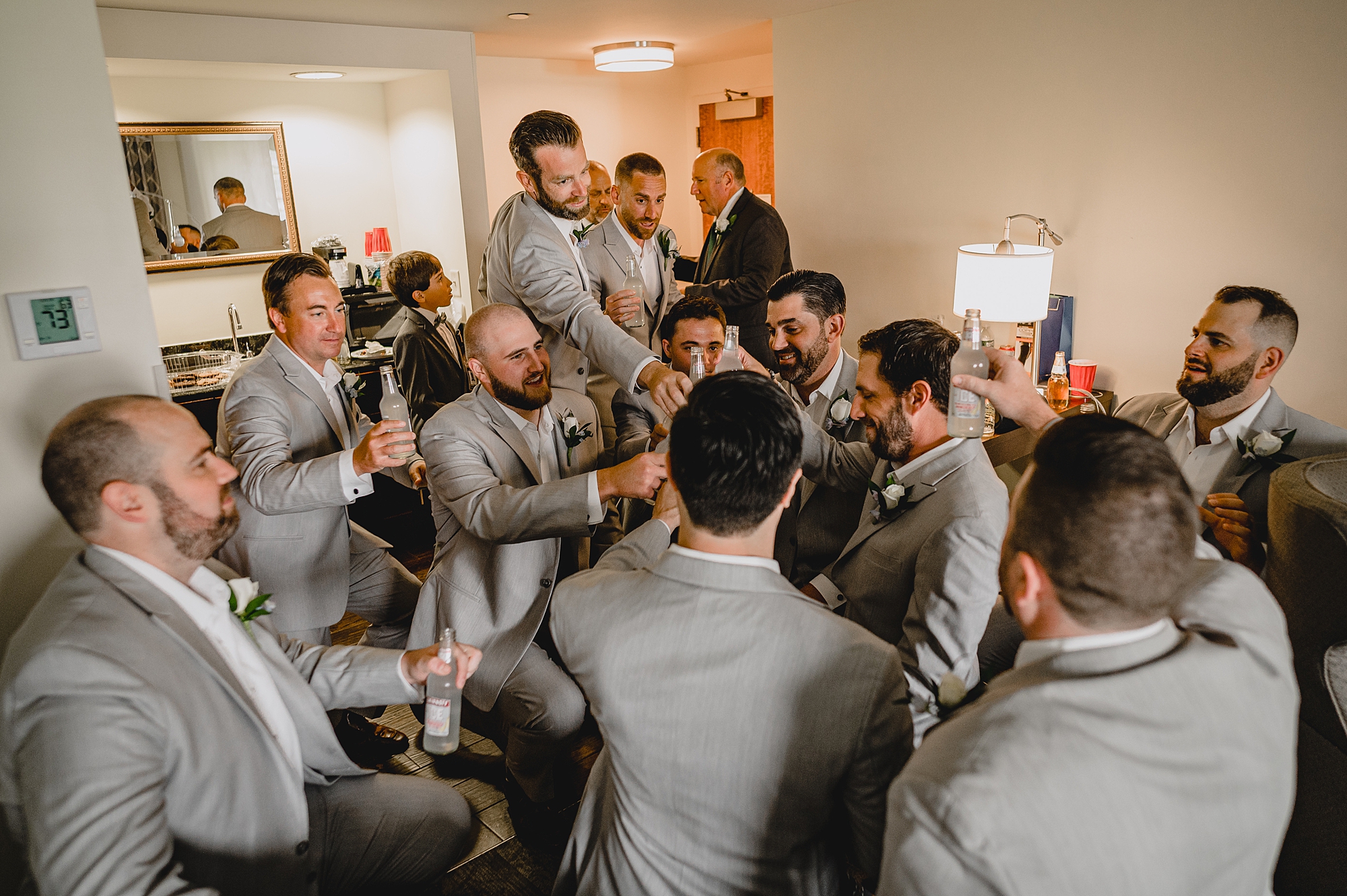 groomsmen toast with groom in hotel room