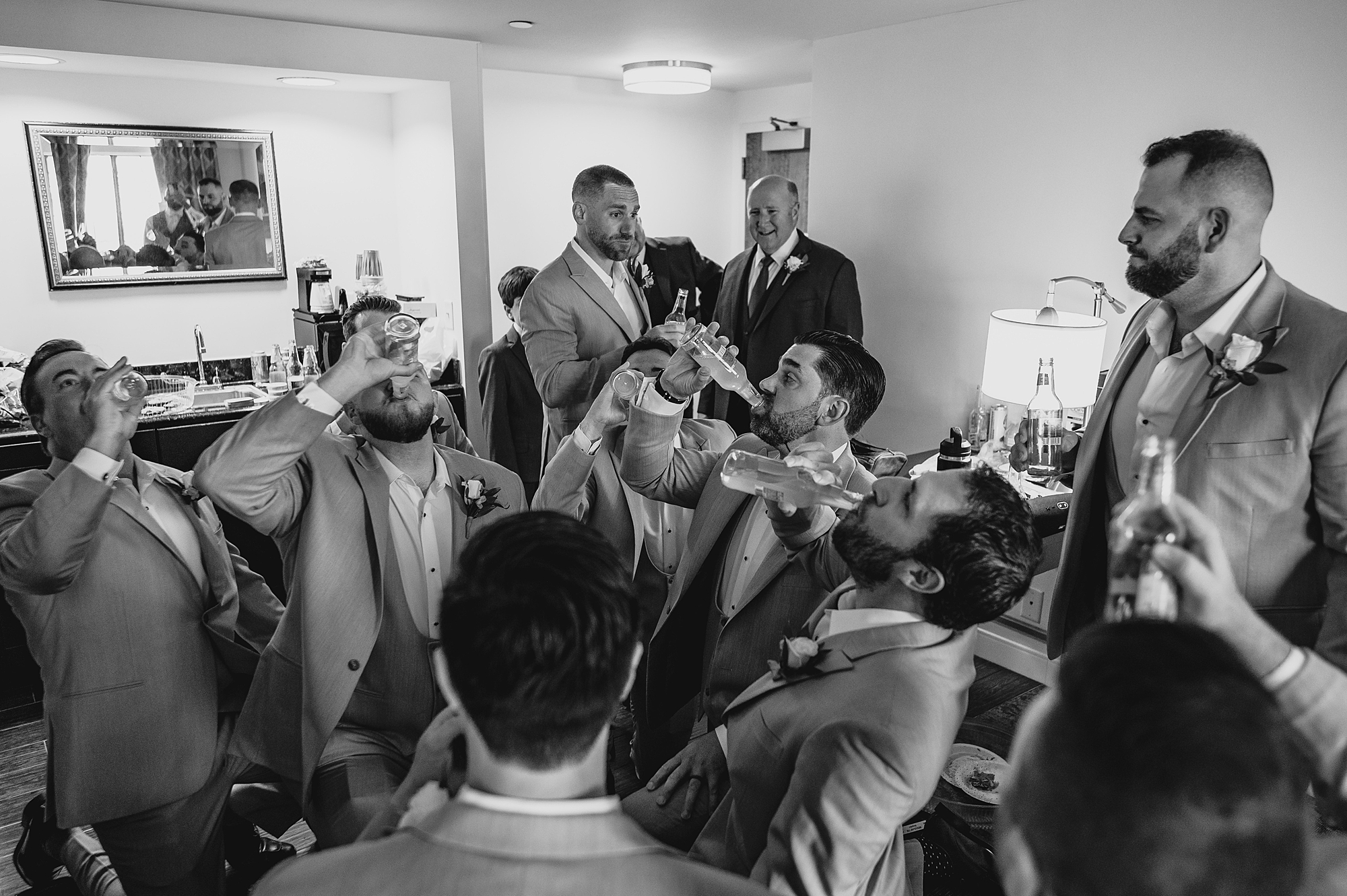 groomsmen toast and drink beers with groom before wedding