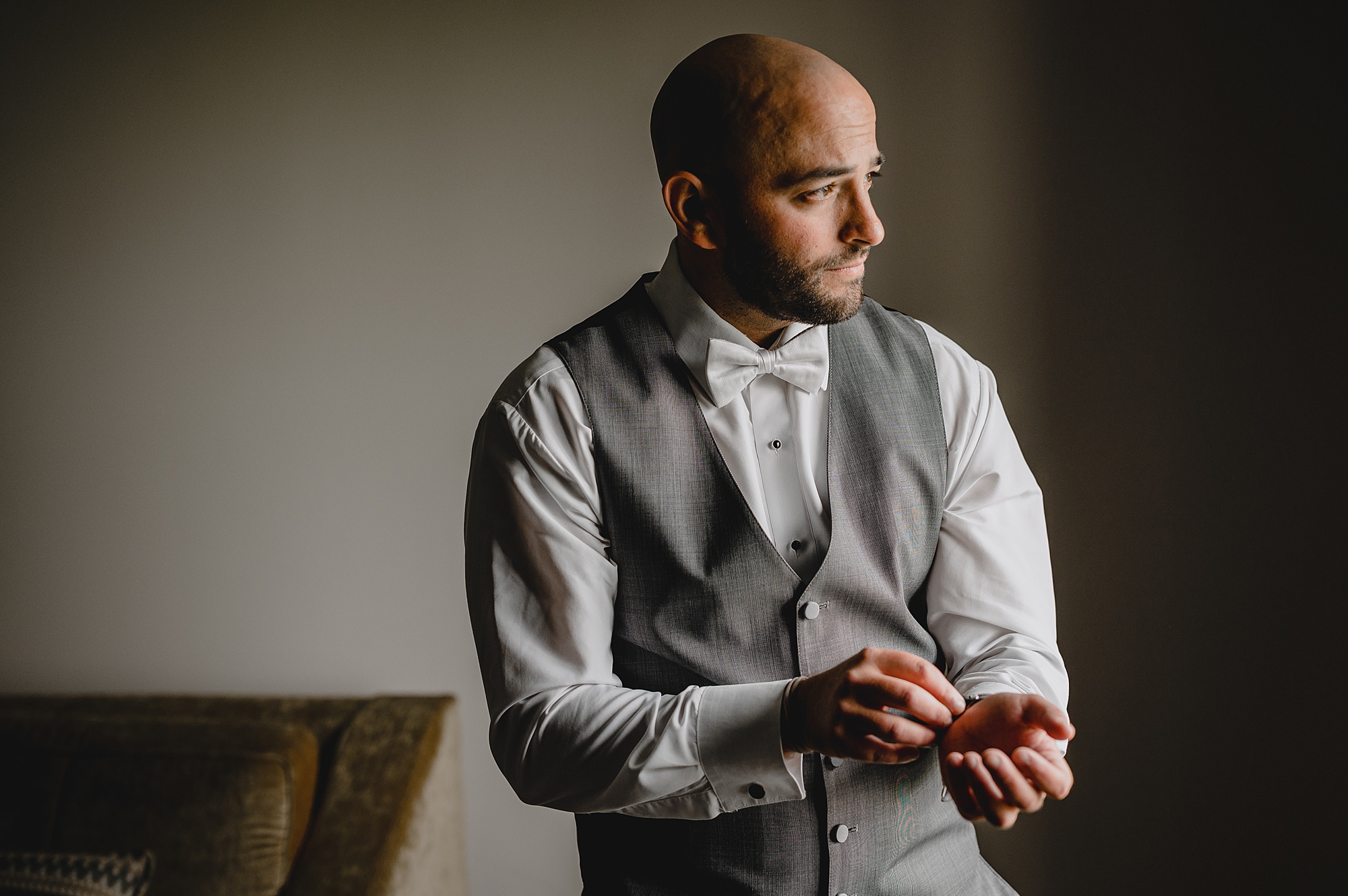 groom adjusts cufflinks on suit shirt