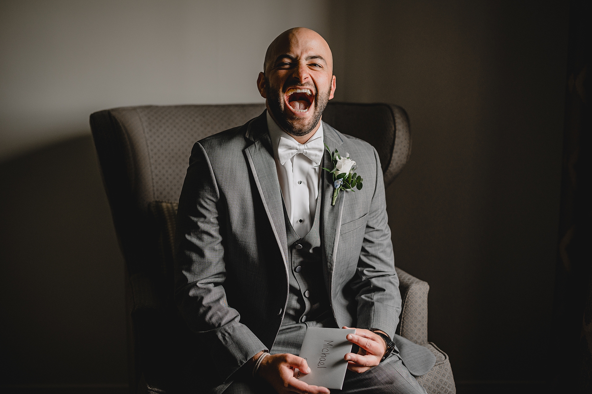 groom laughs reading card from bride