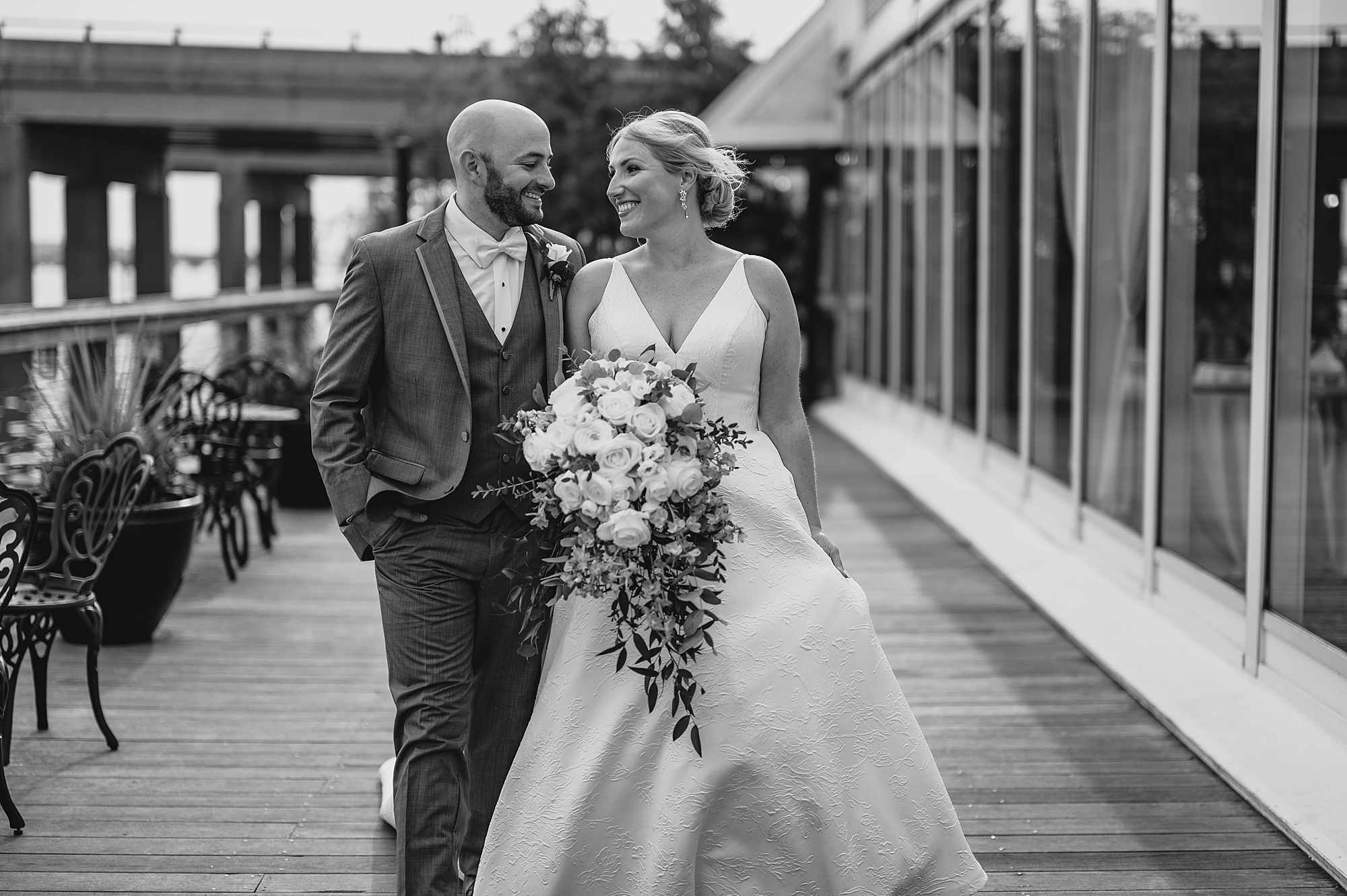 bride and groom smile walking outside Bridgeview Yacht Club