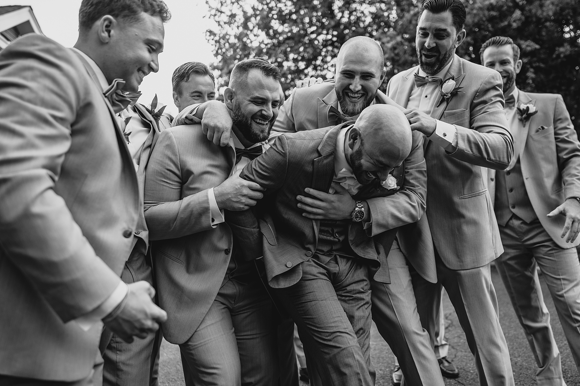 groomsmen tackle groom walking with him