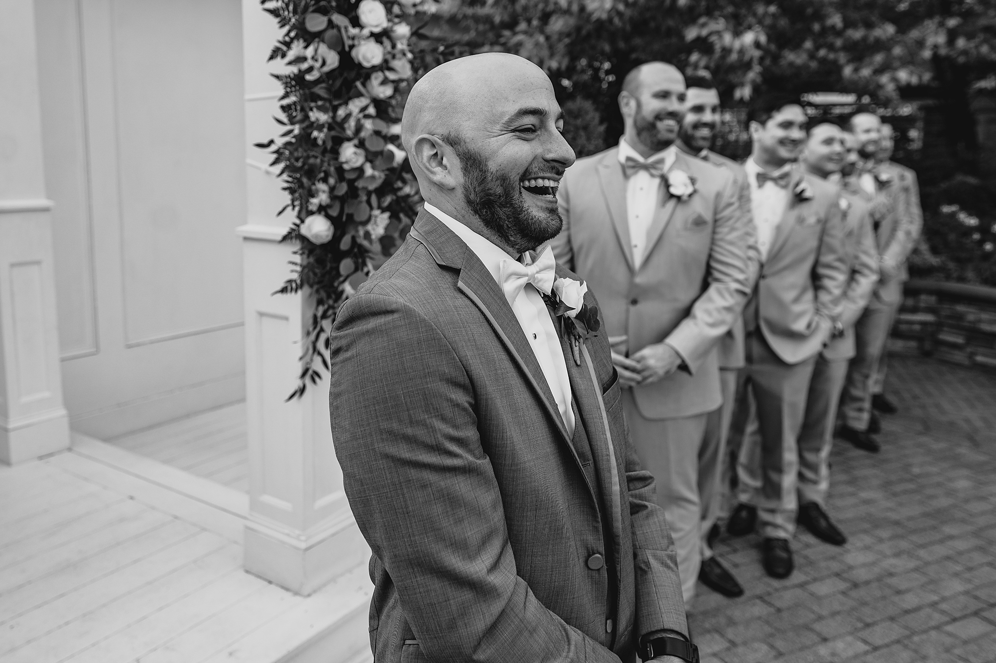 groom grins watching bride walk down aisle at Bridgeview Yacht Club