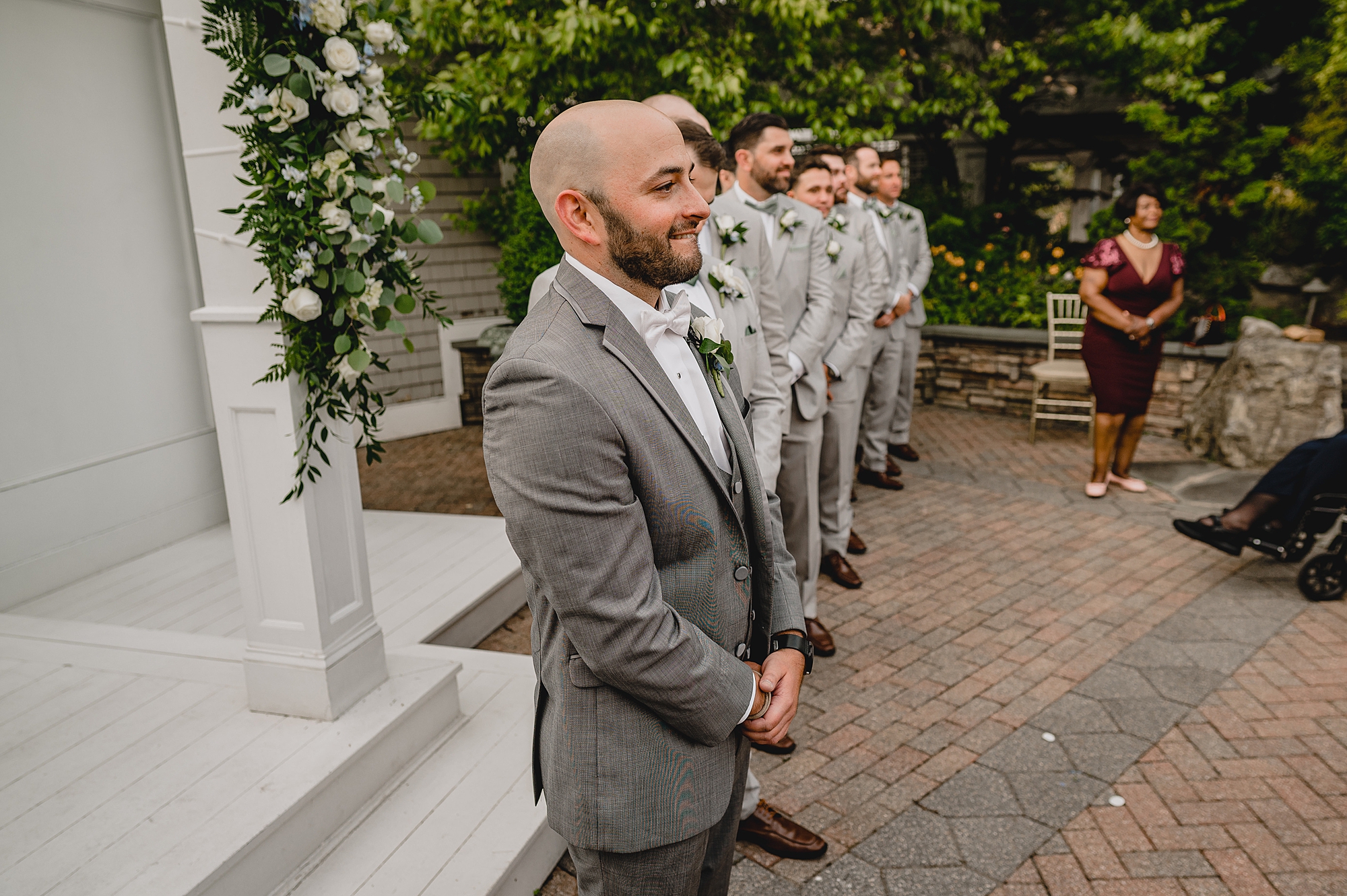 groom in grey suit watches bride walk down the aisle for ceremony at Bridgeview Yacht Club
