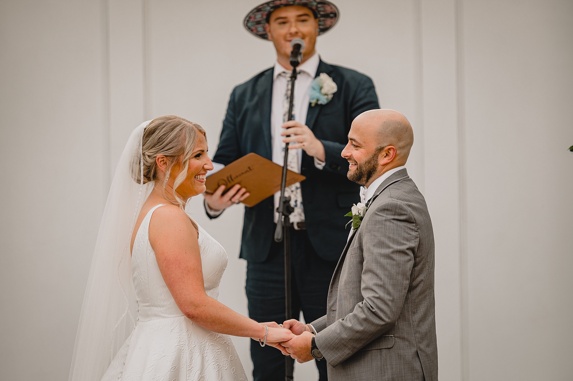 bride and groom hold hands during wedding ceremony at Bridgeview Yacht Club