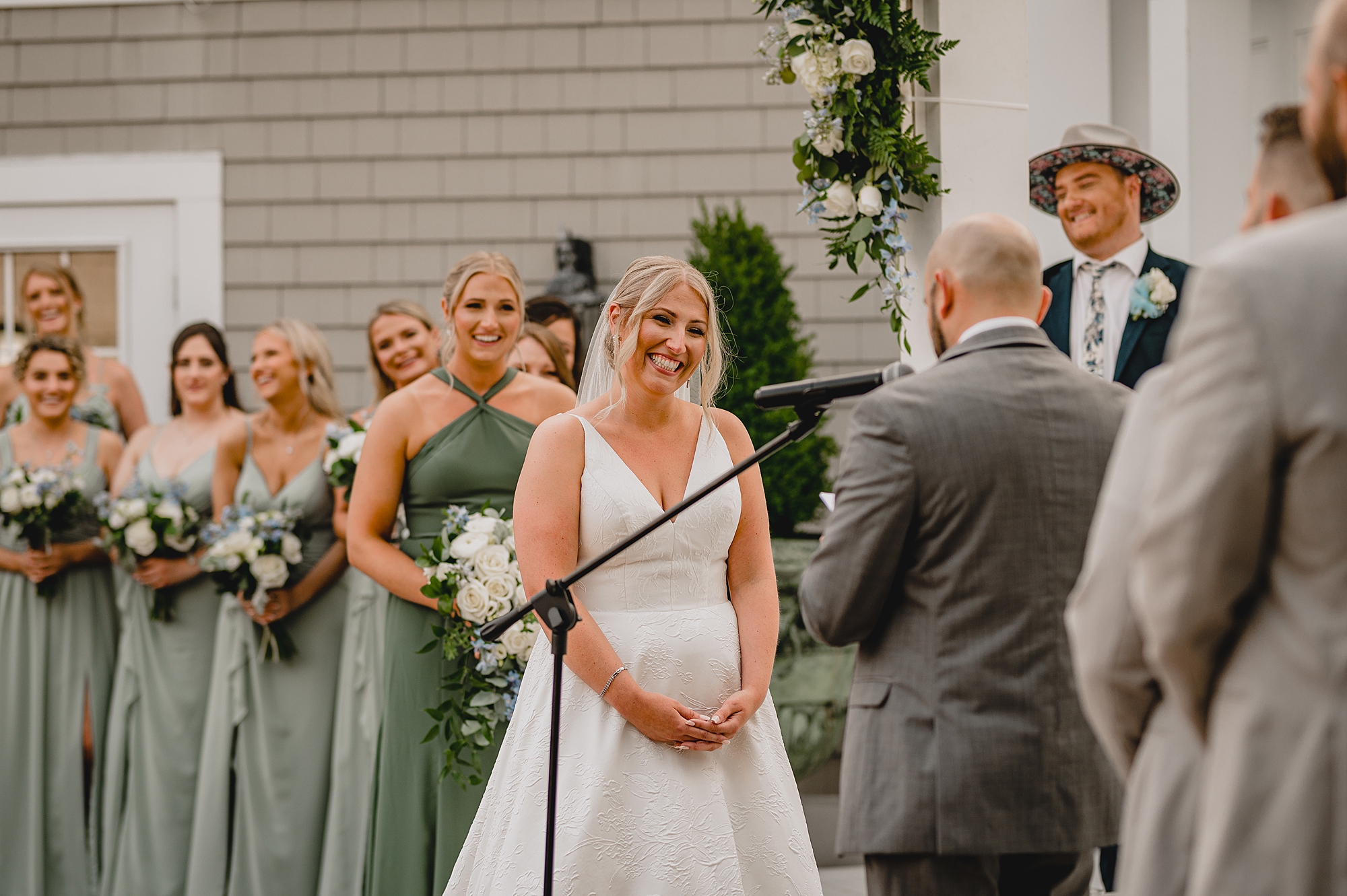 bride grins listening to groom read vows at Bridgeview Yacht Club