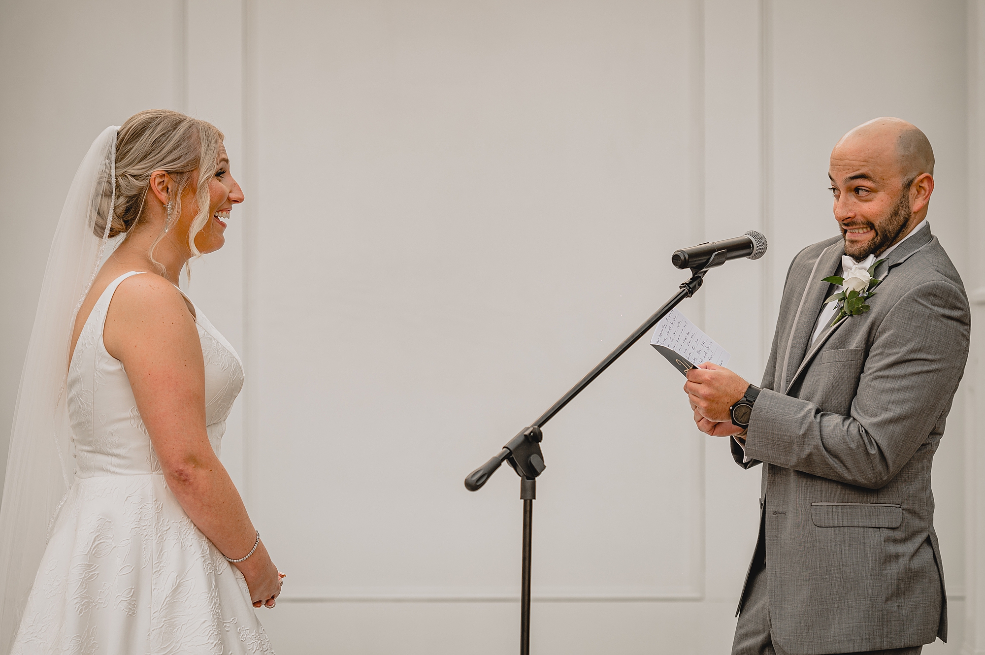 bride and groom smile reading vows at Bridgeview Yacht Club