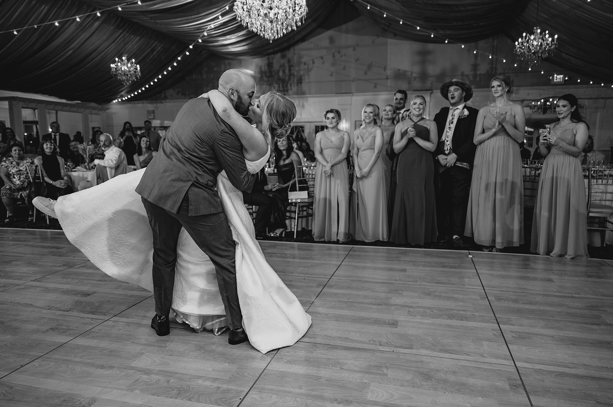 groom starts to dip bride on dance floor at Bridgeview Yacht Club