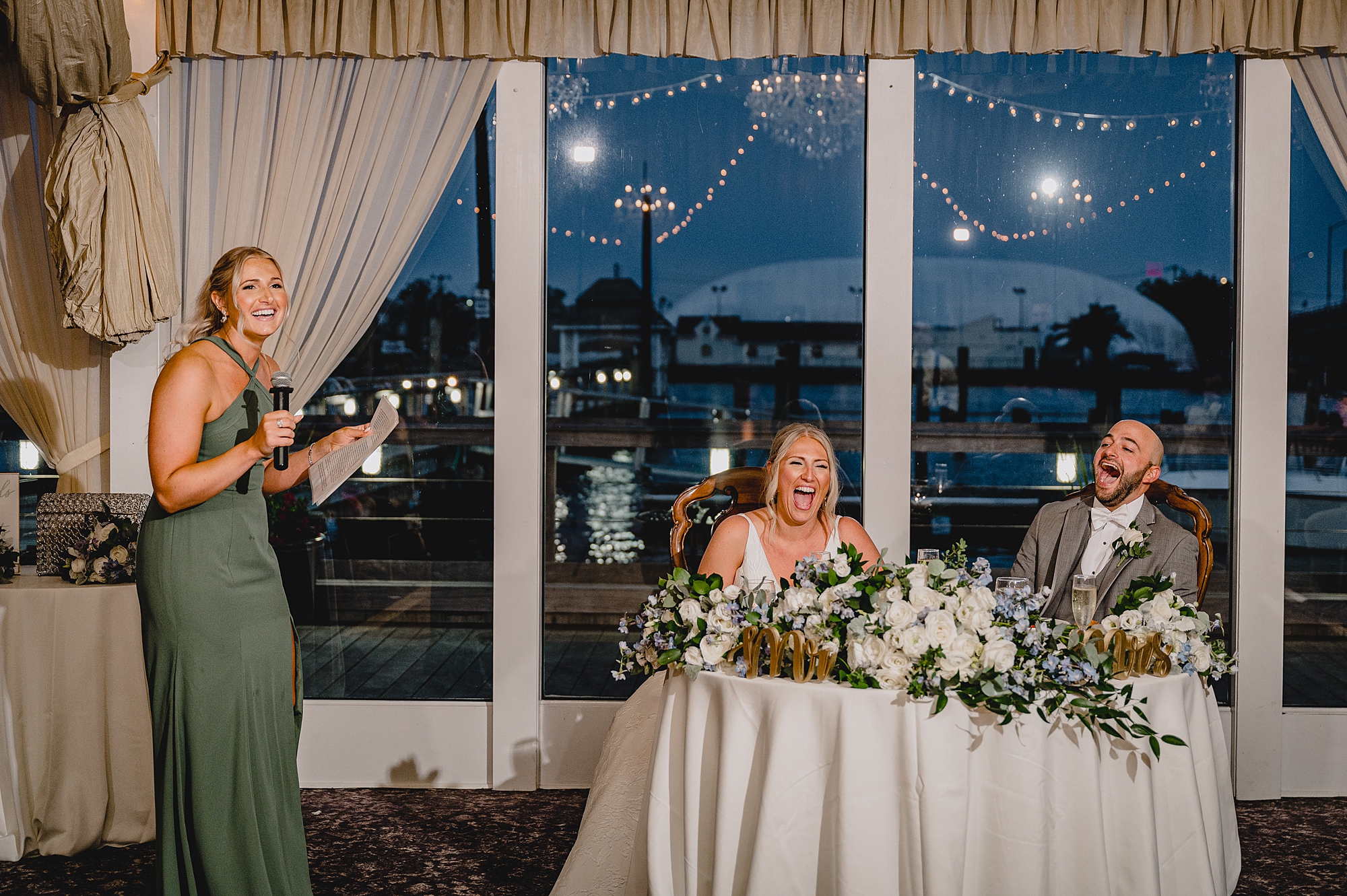bride and groom laugh during wedding reception toasts