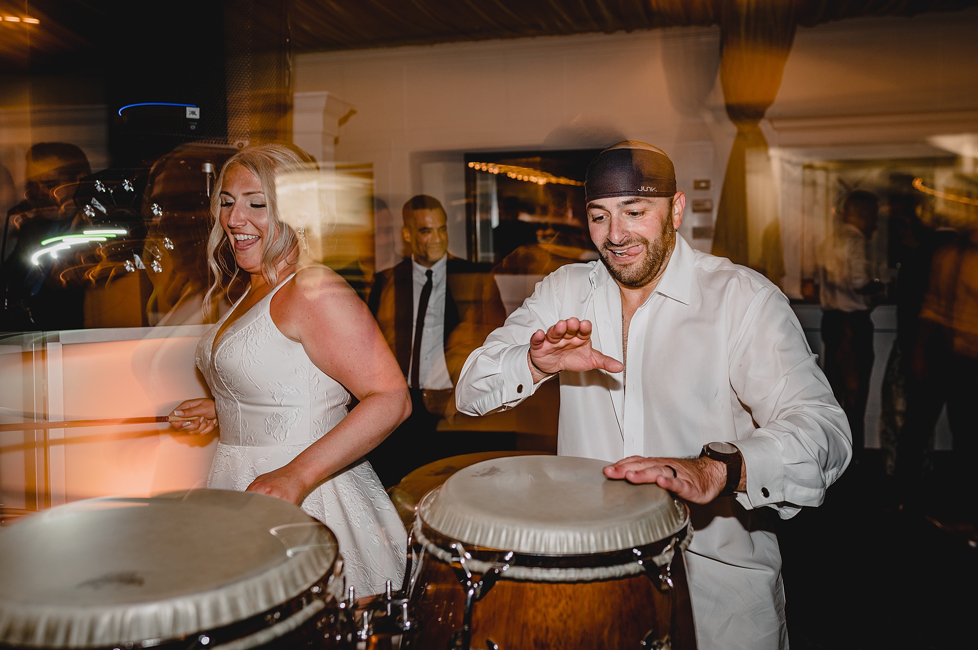 bride and groom play bongos during wedding reception
