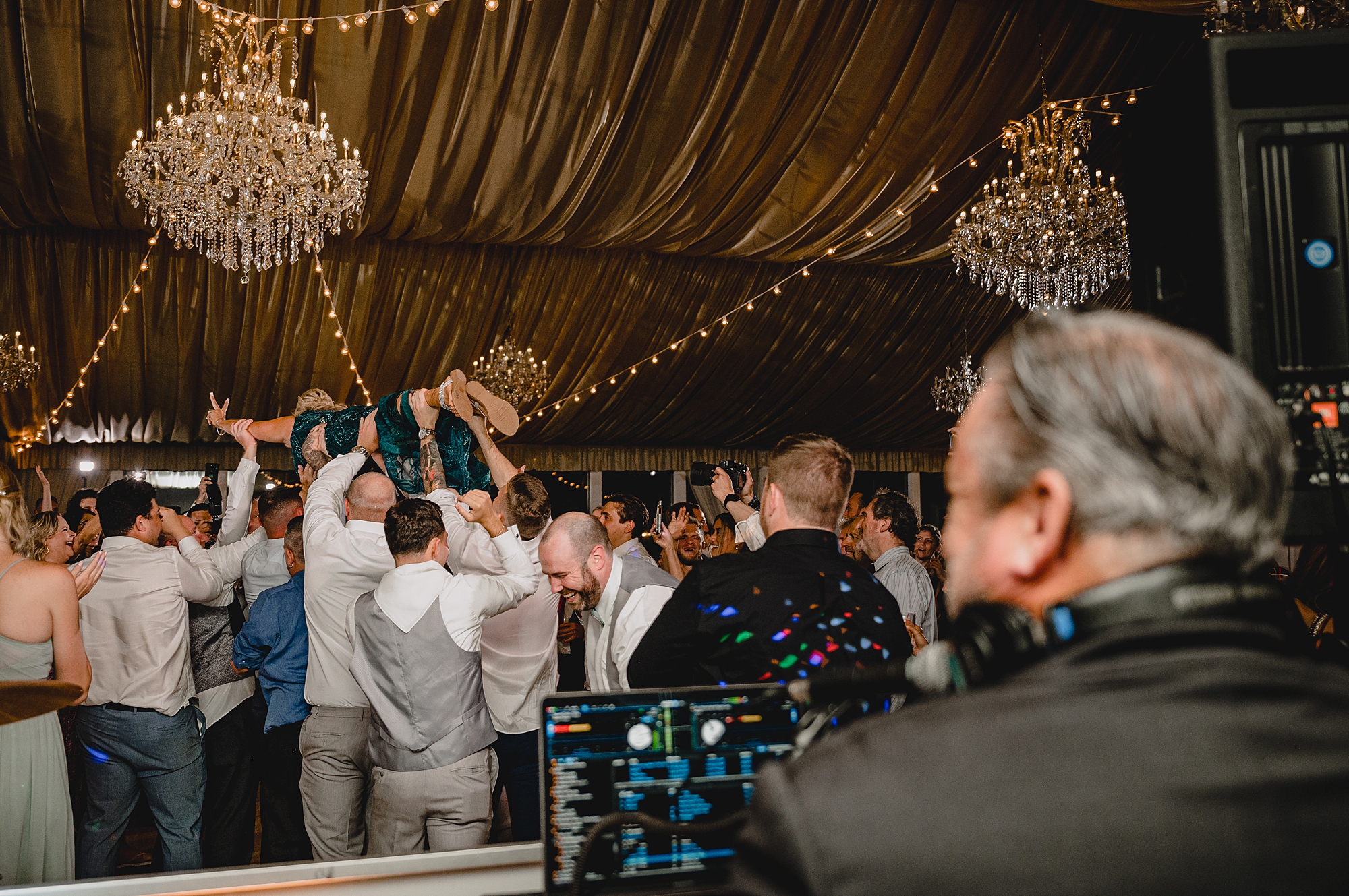 bridesmaid jumps on wedding guests holding her in the air