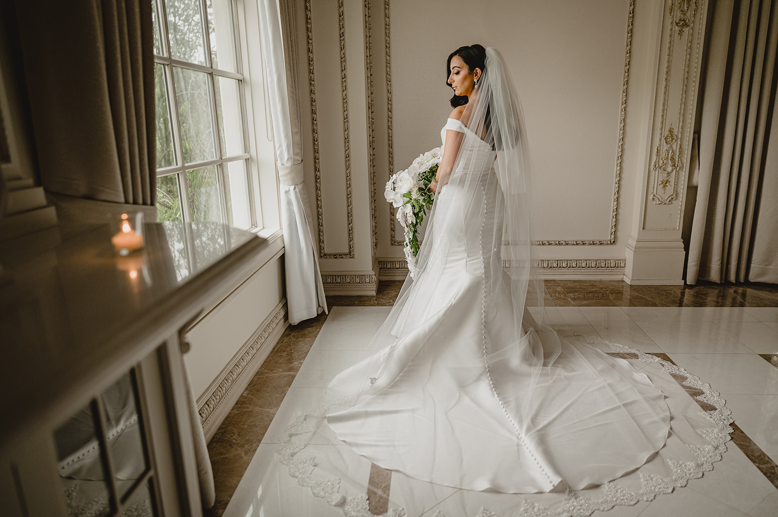bride poses by window inside the Venetian  bridal suite