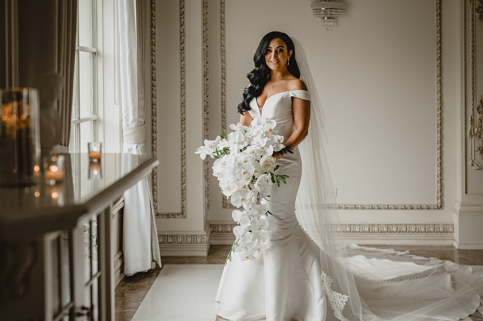 bride holds bouquet of cascading orchids in suite at the Venetian