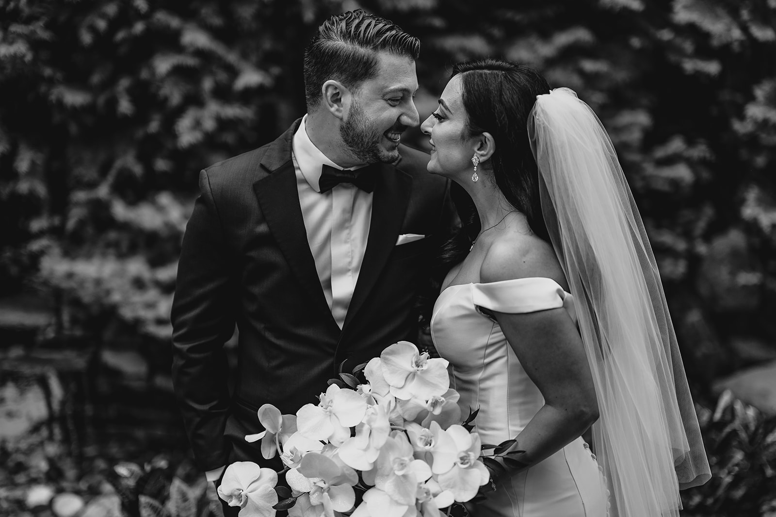 bride and groom lean heads together during portraits in garden