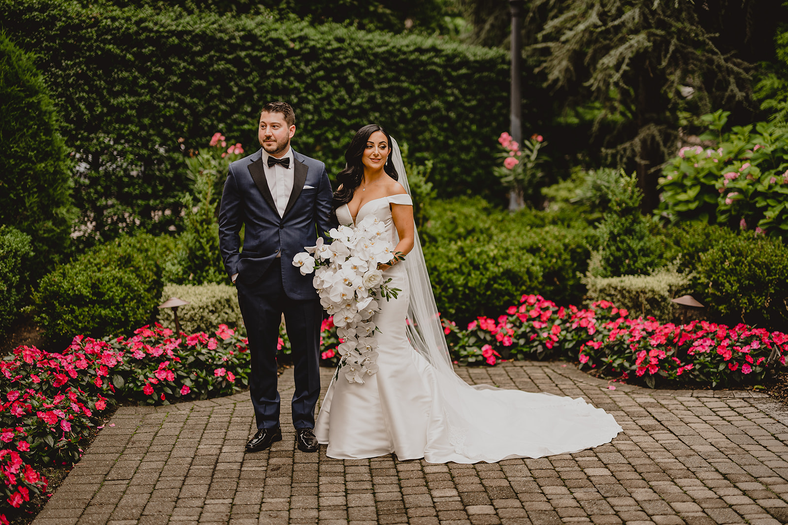 bride and groom stand together looking opposite ways in gardens of the Venetian