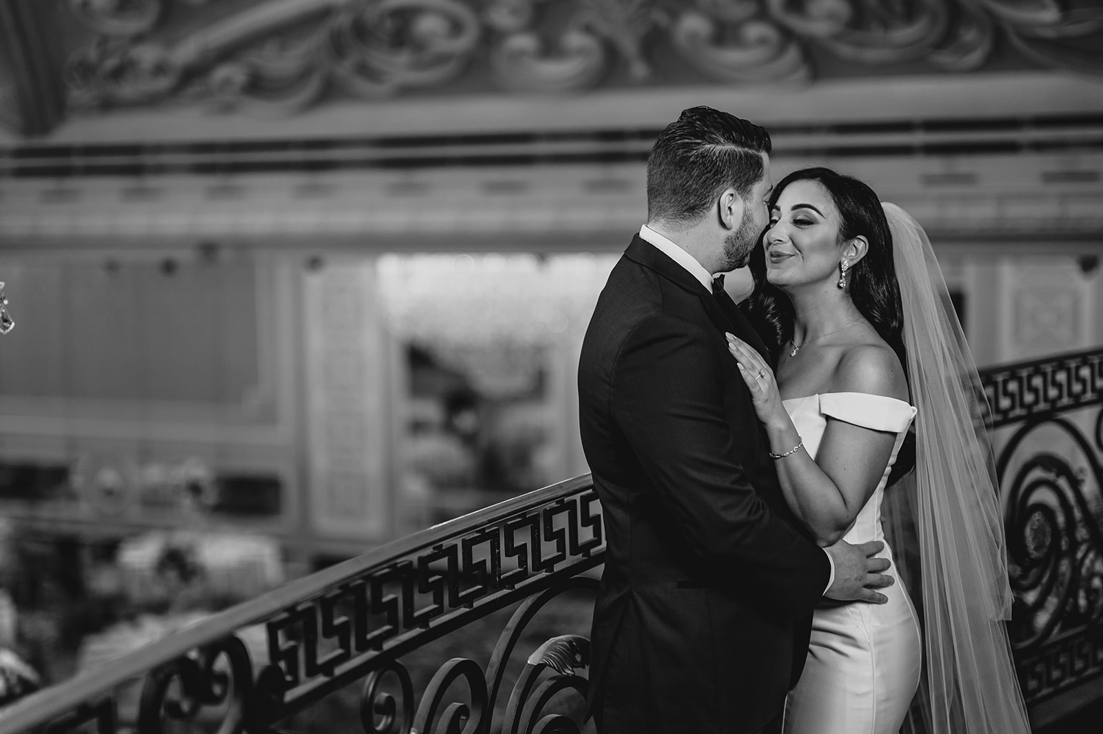 bride holds groom's lapel to kiss him on balcony of the Venetian