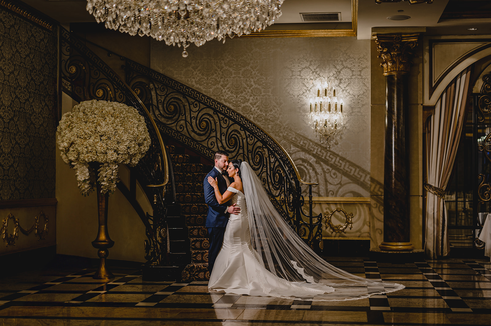 bride and groom hug at the bottom of the staircase inside the Venetian
