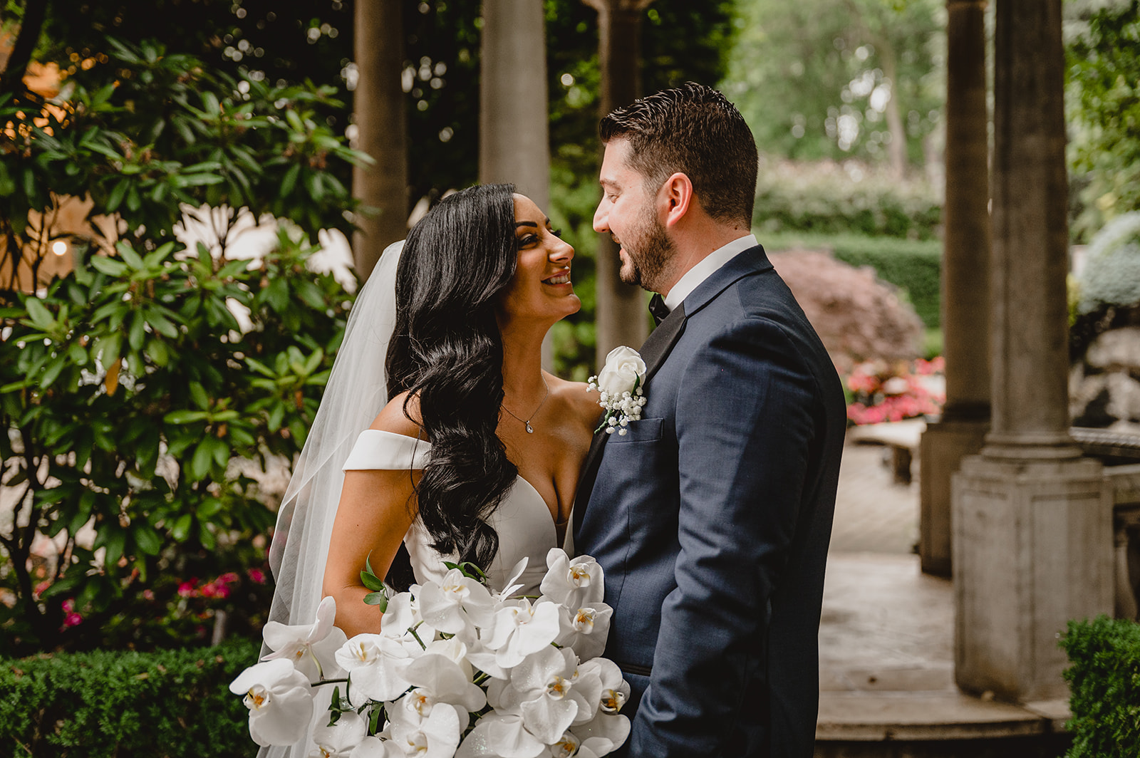newlyweds smile by gazebo in the gardens of the Venetian
