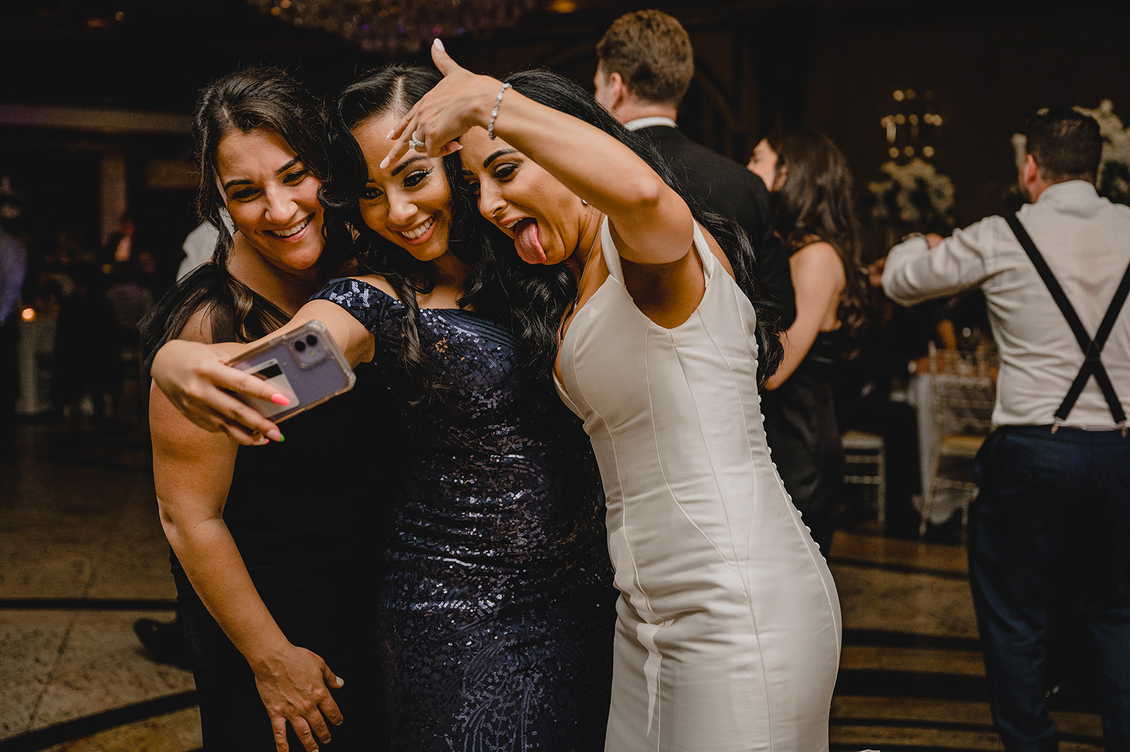 bride and guests pose for photo on iPhone