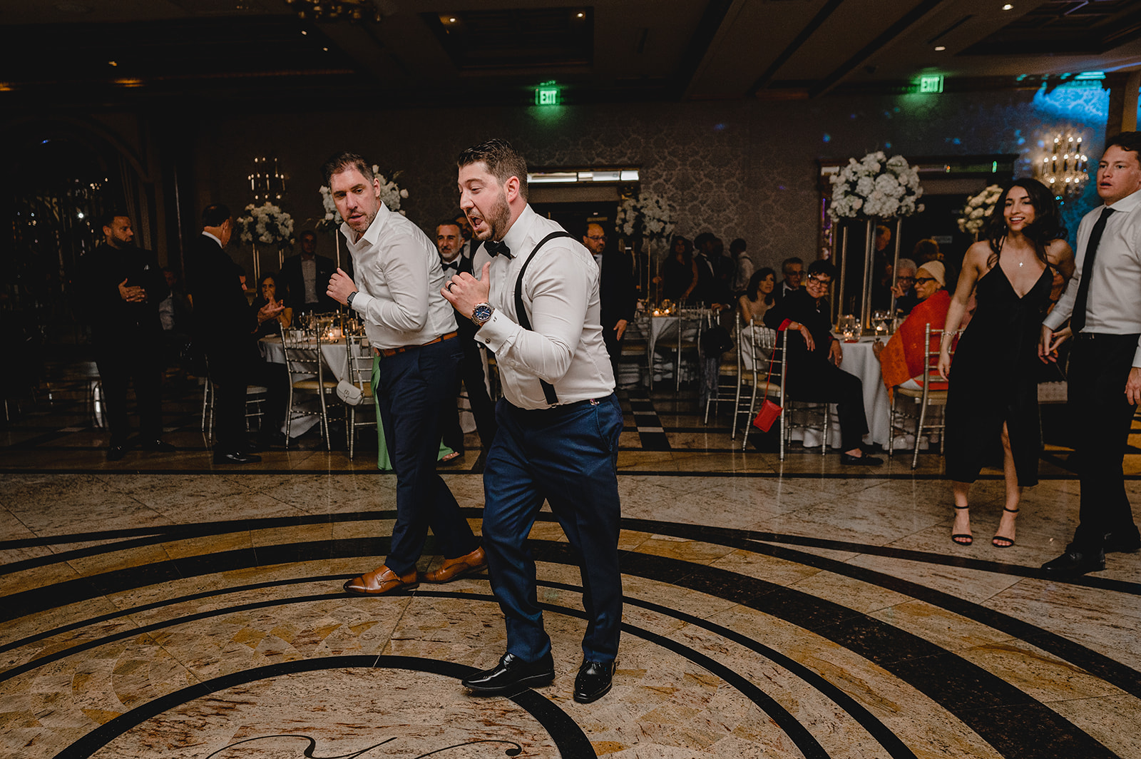 groomsmen dance in suspenders in ballroom of NJ venue