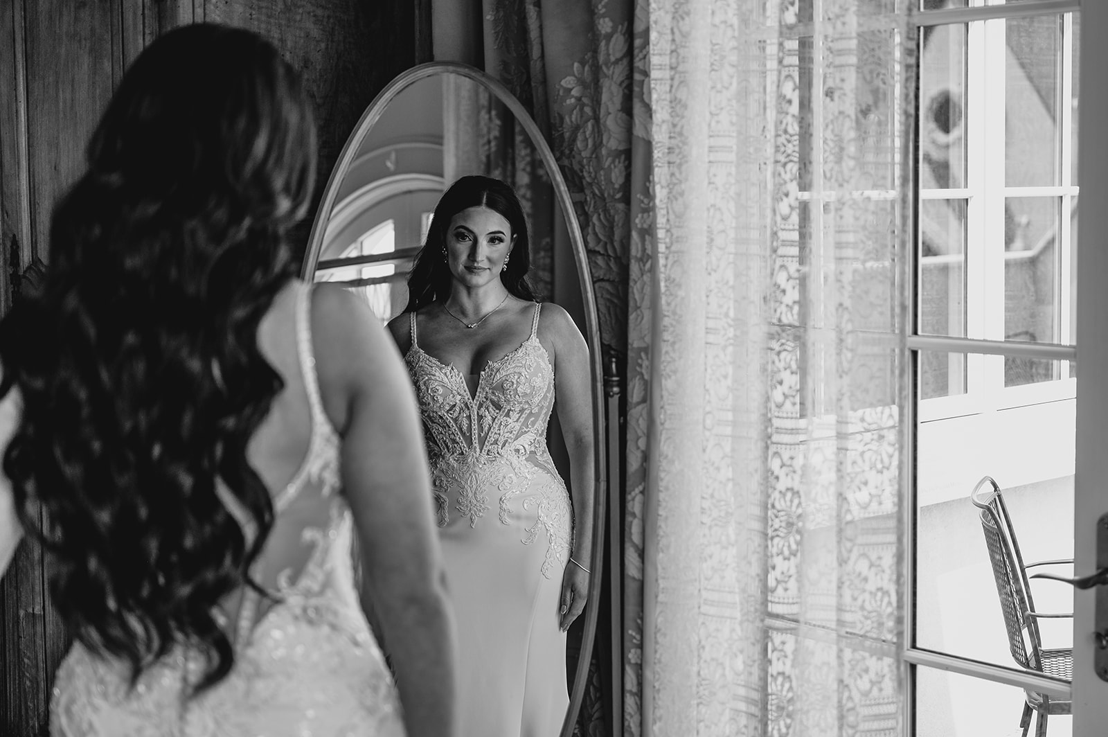 bride looks at herself in mirror of bridal suite at Park Chateau Estate