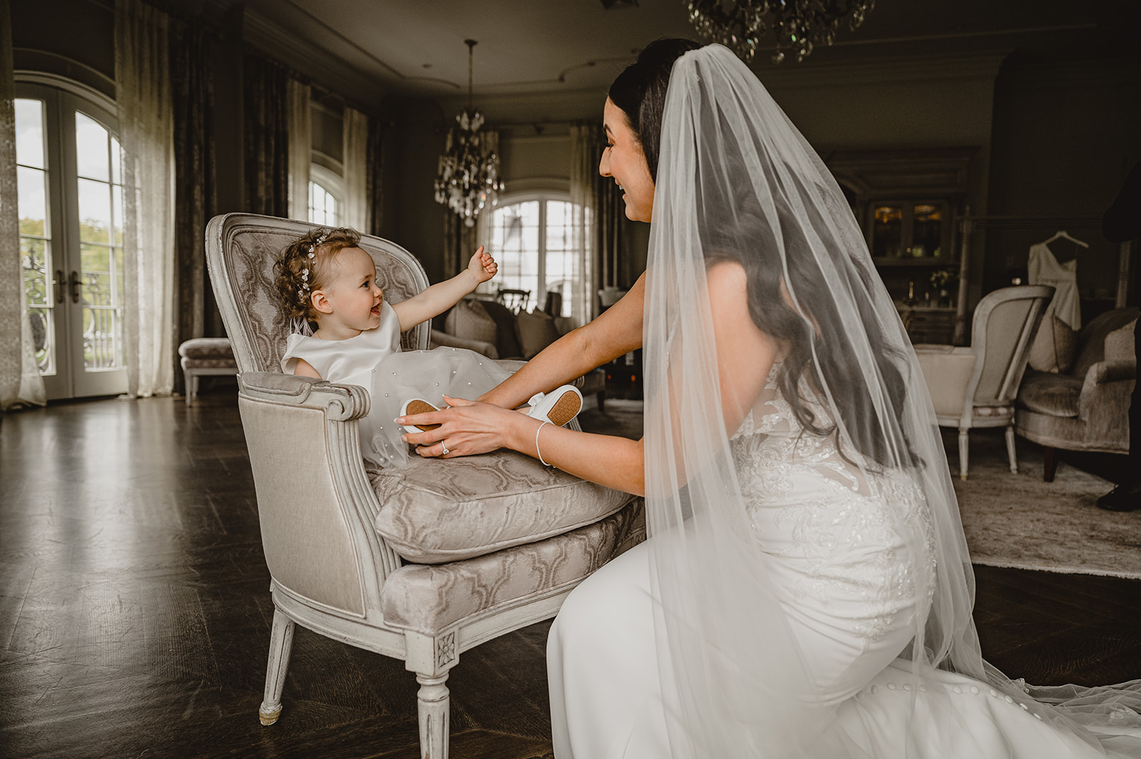 bride reaches for flower girl in bridal suite at Park Chateau Estate