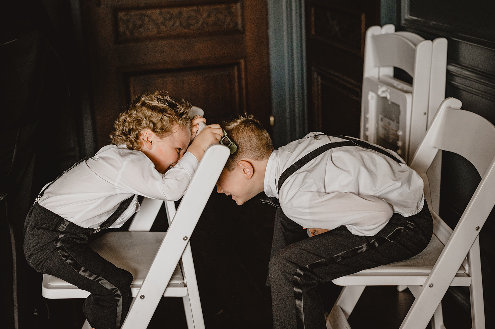 kids play in folding chairs in groom's getting ready suite