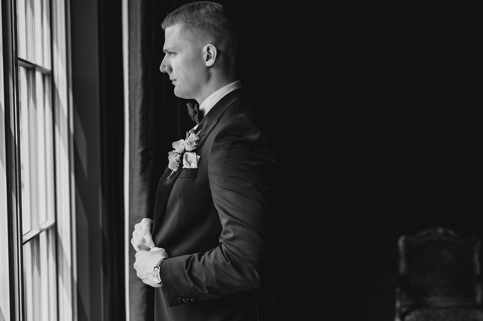 groom pulls jacket around his chest