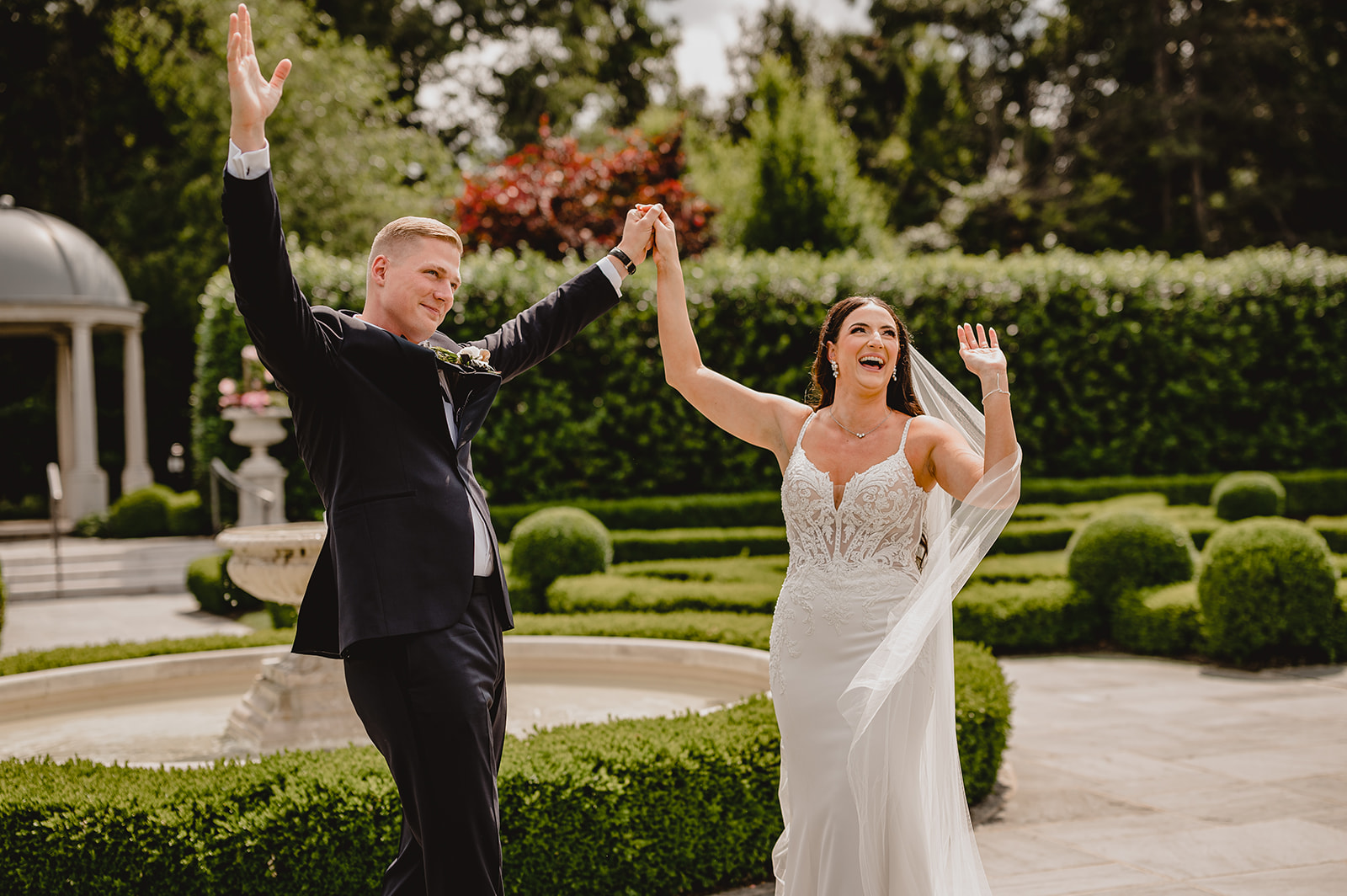 bride and groom cheer during first look in gardens of Park Chateau Estate