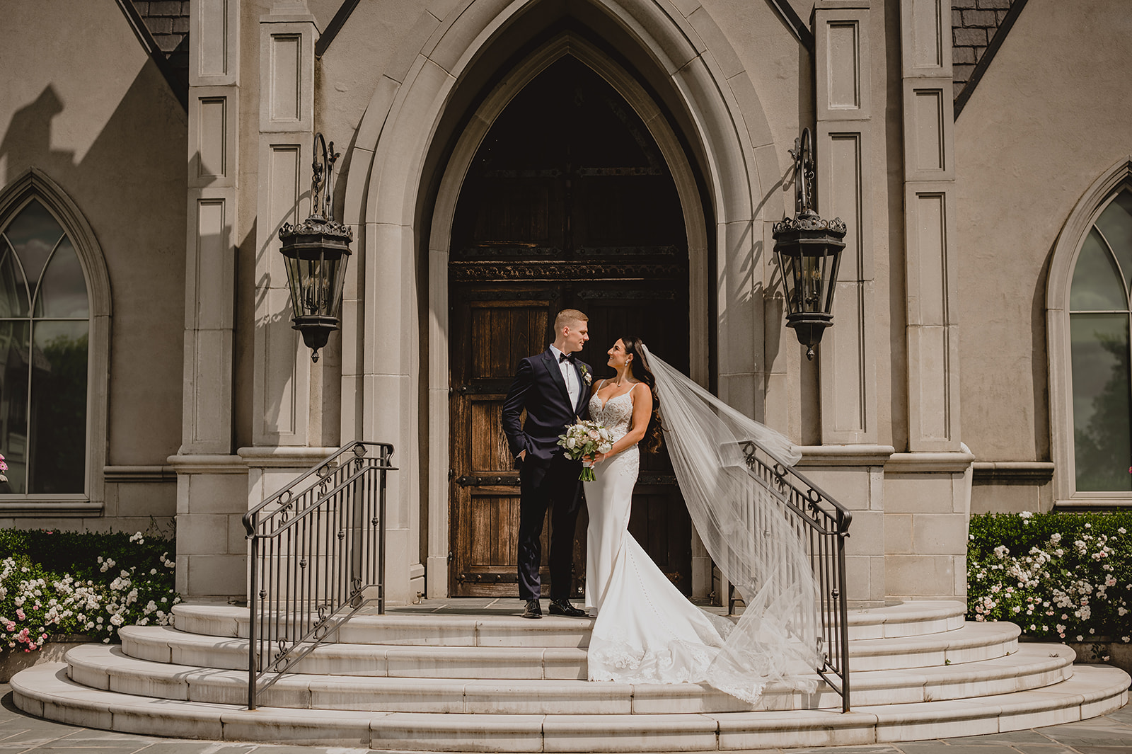 newlyweds hug on steps of Park Chateau chapel