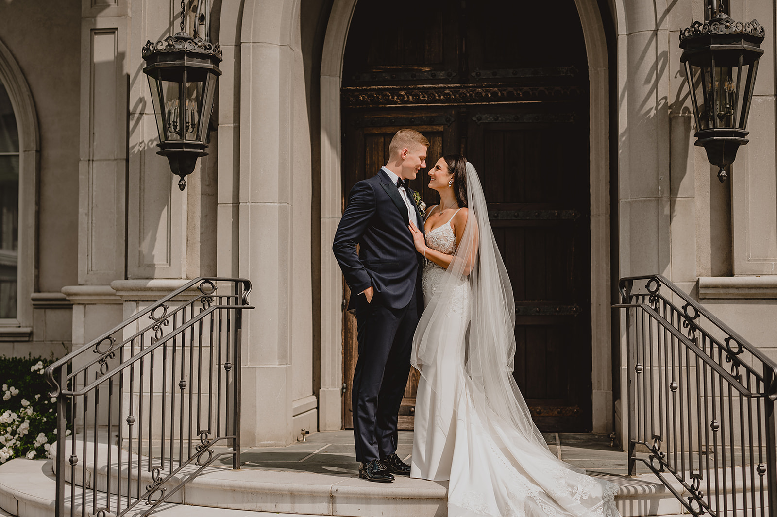 bride and groom hug smiling at each other on top steps of Park Chateau chapel